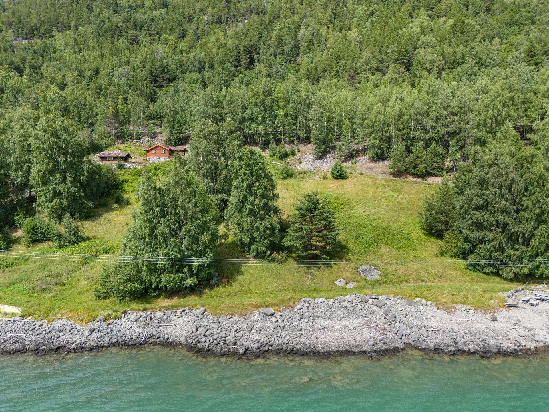 Tomten har en naturskjønn beliggenhet ved Vågåvatnet.. Bilde nummer 2 av 3