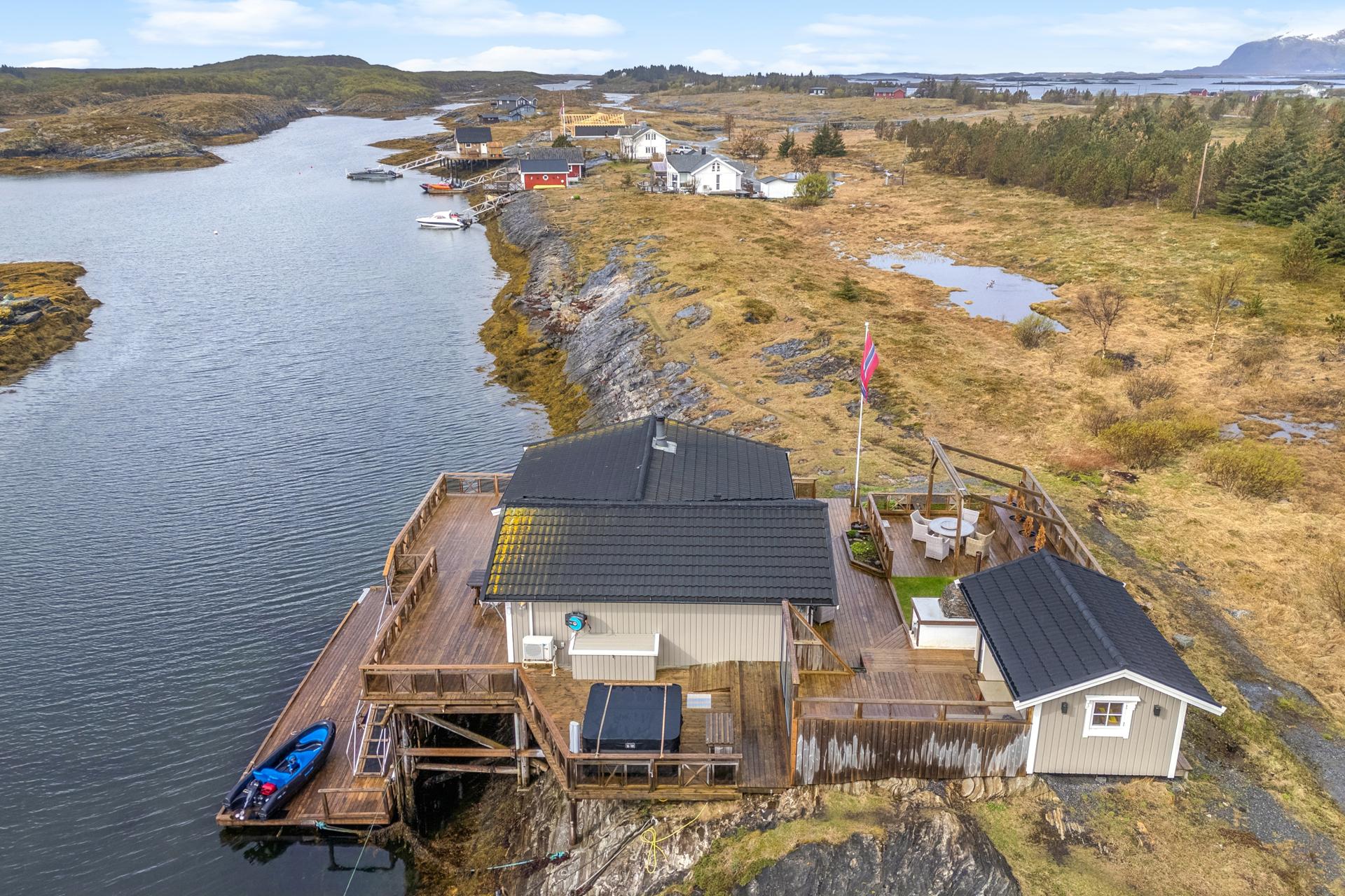De store uteområdene på totalt 215 m² omkranser hytta og inkluderer en ny jacuzzi fra 2024, flere soner for uteliv og direkte tilgang til havet.. Bilde nummer 3 av 3