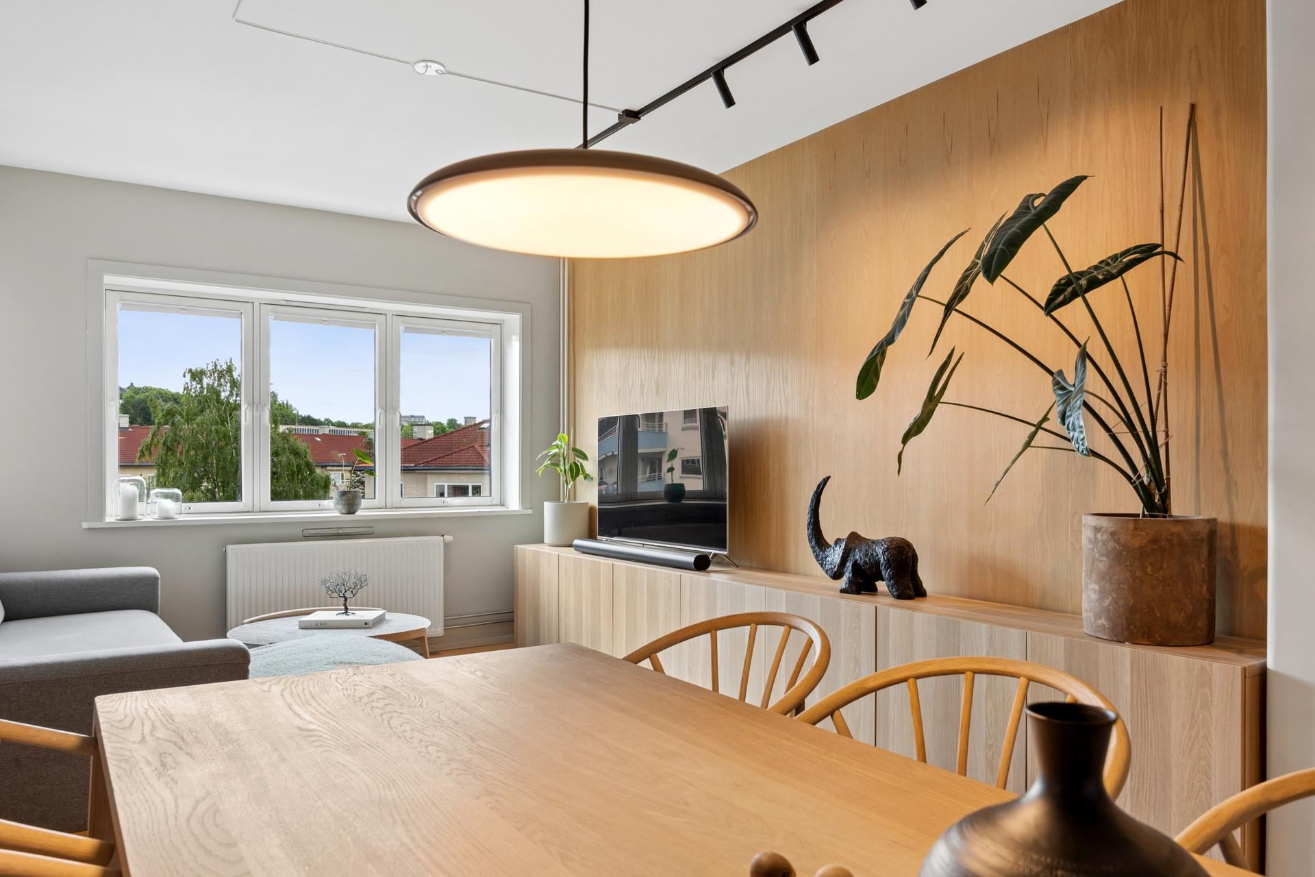 Stuen har plass til både spisebord og sofagruppe, med en sjenerøs takhøyde på 2,6 meter.. Bilde nummer 2 av 3