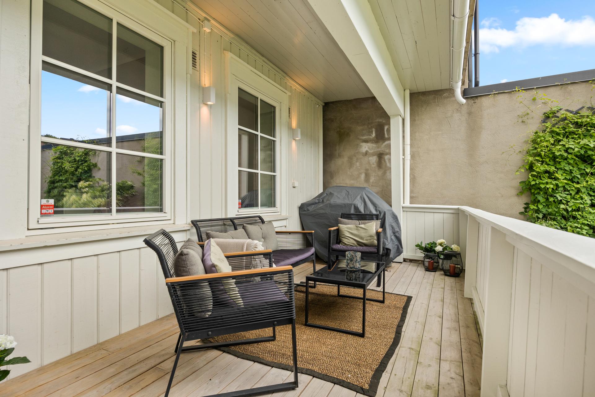 Privat, overbygget veranda på 13 m² utenfor inngangsdøren. Plass til en hyggelig sittegruppe. Uteplassen vender mot syd/øst.. Bilde nummer 2 av 3
