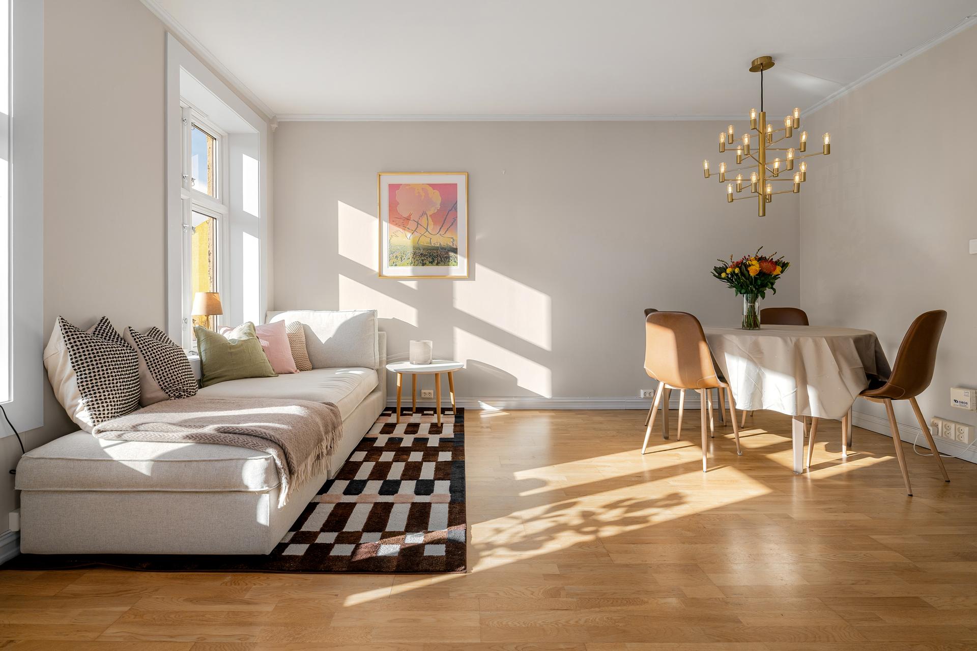 Stuen har en sjenerøs takhøyde og god plass til både sofagruppe og spisebord.. Bilde nummer 2 av 3