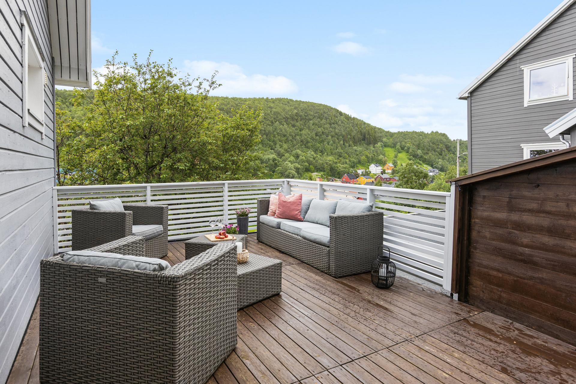 Stor terrasse med god plass til utemøbler og utsikt mot de grønne omgivelsene.. Bilde nummer 3 av 3