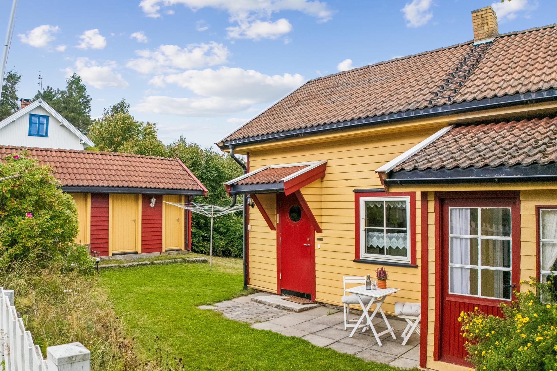 En idyllisk eiendom med frodig hage, og et romslig uthus fra 2002.. Bilde nummer 3 av 3
