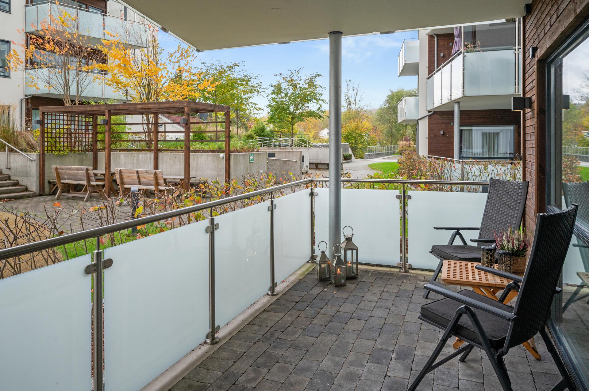Overbygd terrasse med hyggelig utsyn mot fellesarealene.. Bilde nummer 3 av 3