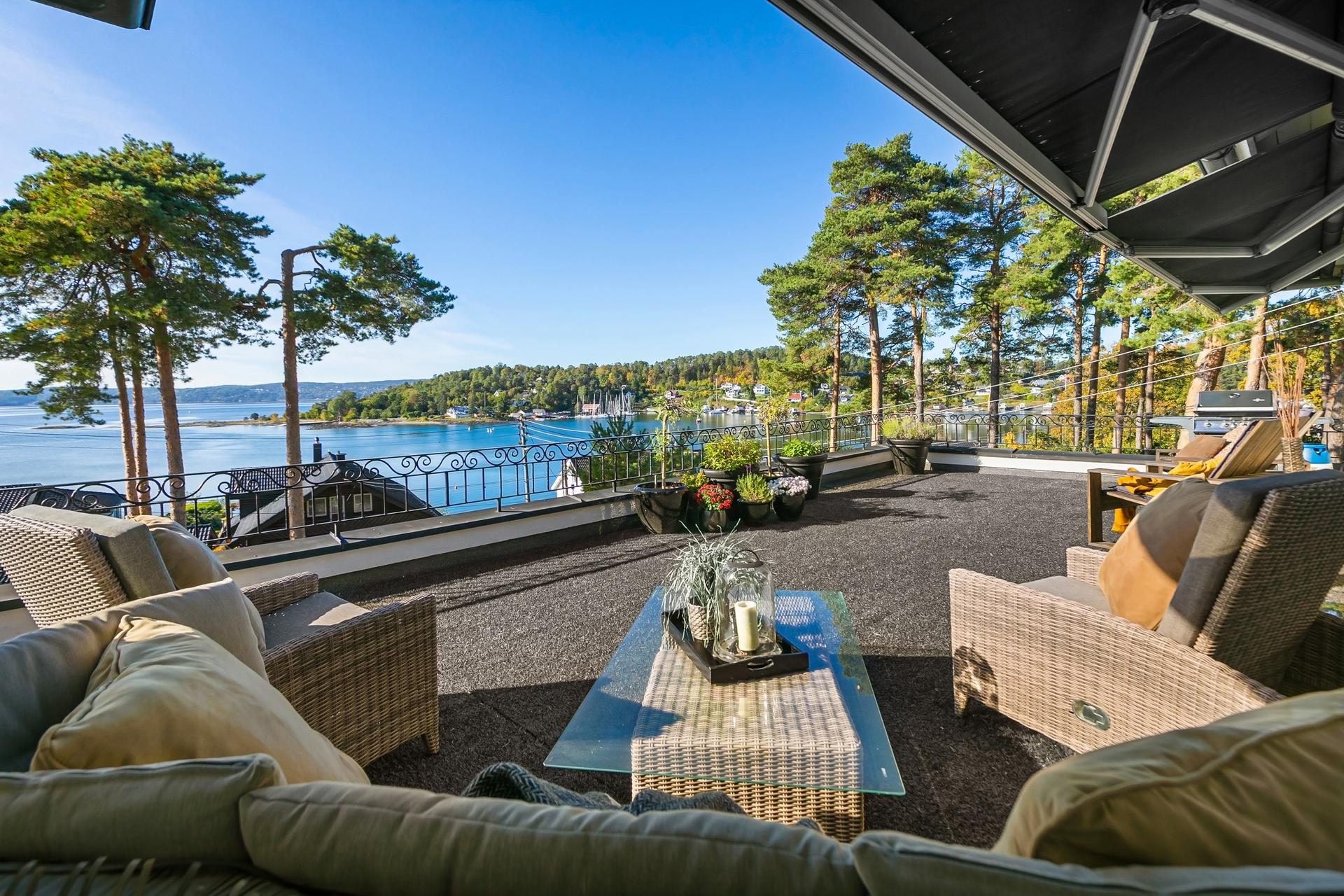 Sydvestvendt terrasse med vidstrakt fjordutsikt, elektriske markiser og god plass til flere sittegrupper.. Bilde nummer 3 av 3