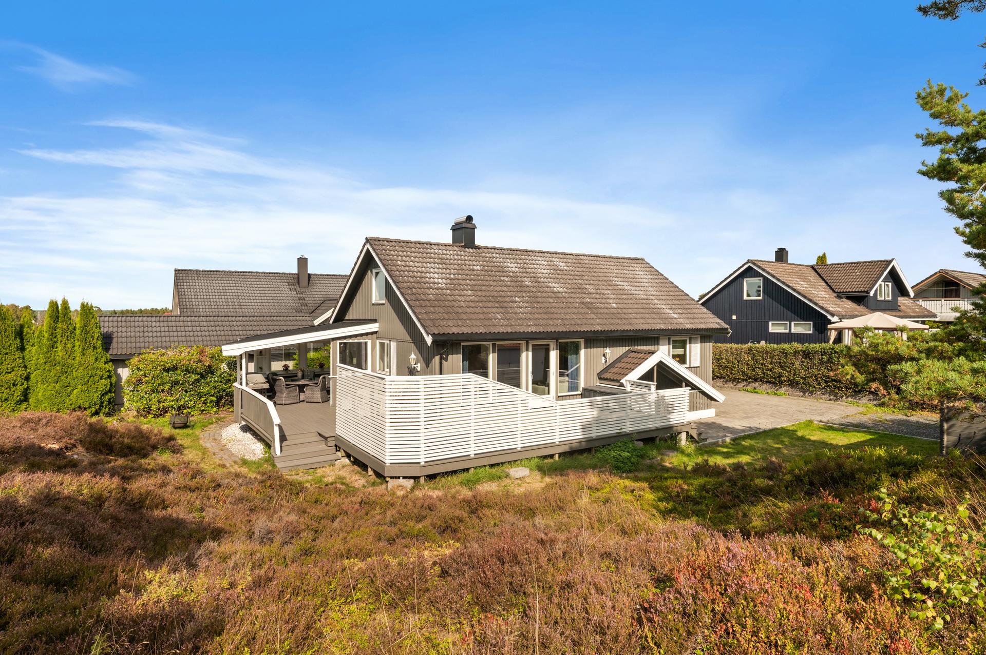 Eiendommen ligger på en relativt flat tomt med naturtomt i bakkant.. Bilde nummer 3 av 3