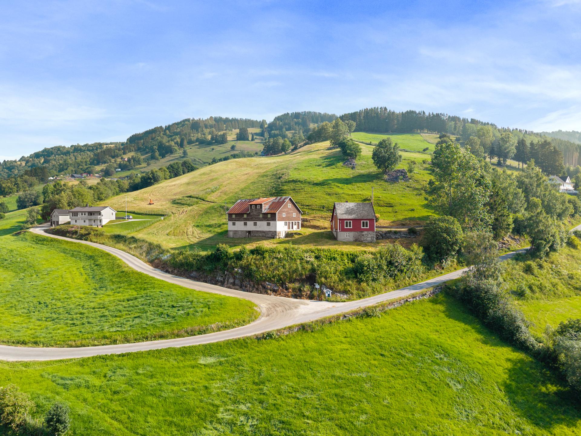 Eigedomen ligg landleg til i eit område beståande av bustader og landbruk.. Bilde nummer 3 av 3