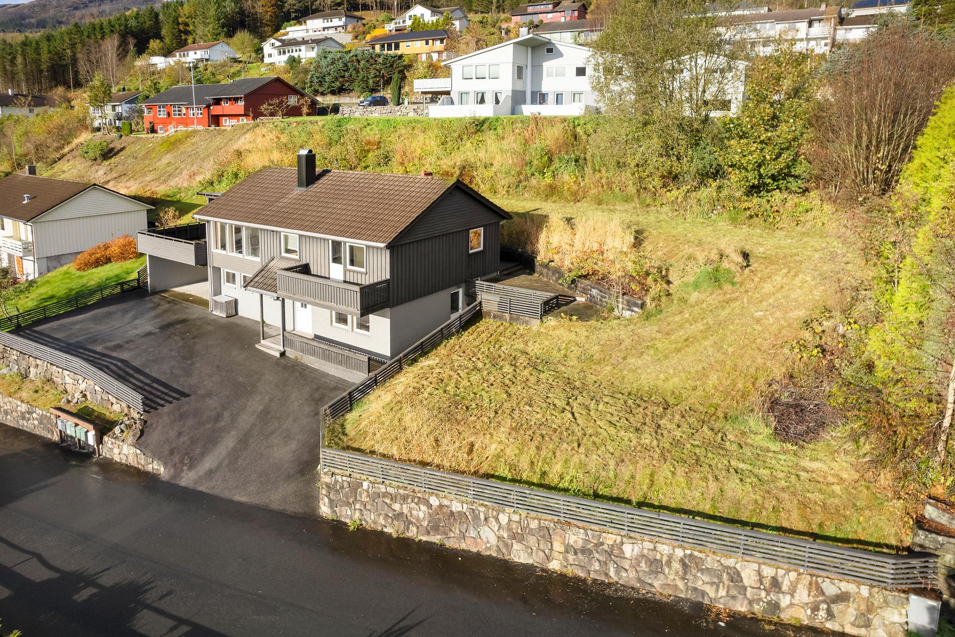 Innholdsrik enebolig med stor tomt, asfaltert gårdsrom og hage bak huset.. Bilde nummer 2 av 3