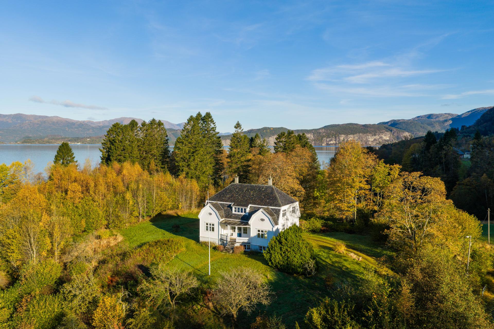Hovedhuset ligger tilbaketrukket med fri utsikt mot Samnangerfjorden og de omkringliggende fjellene.. Bilde nummer 2 av 3