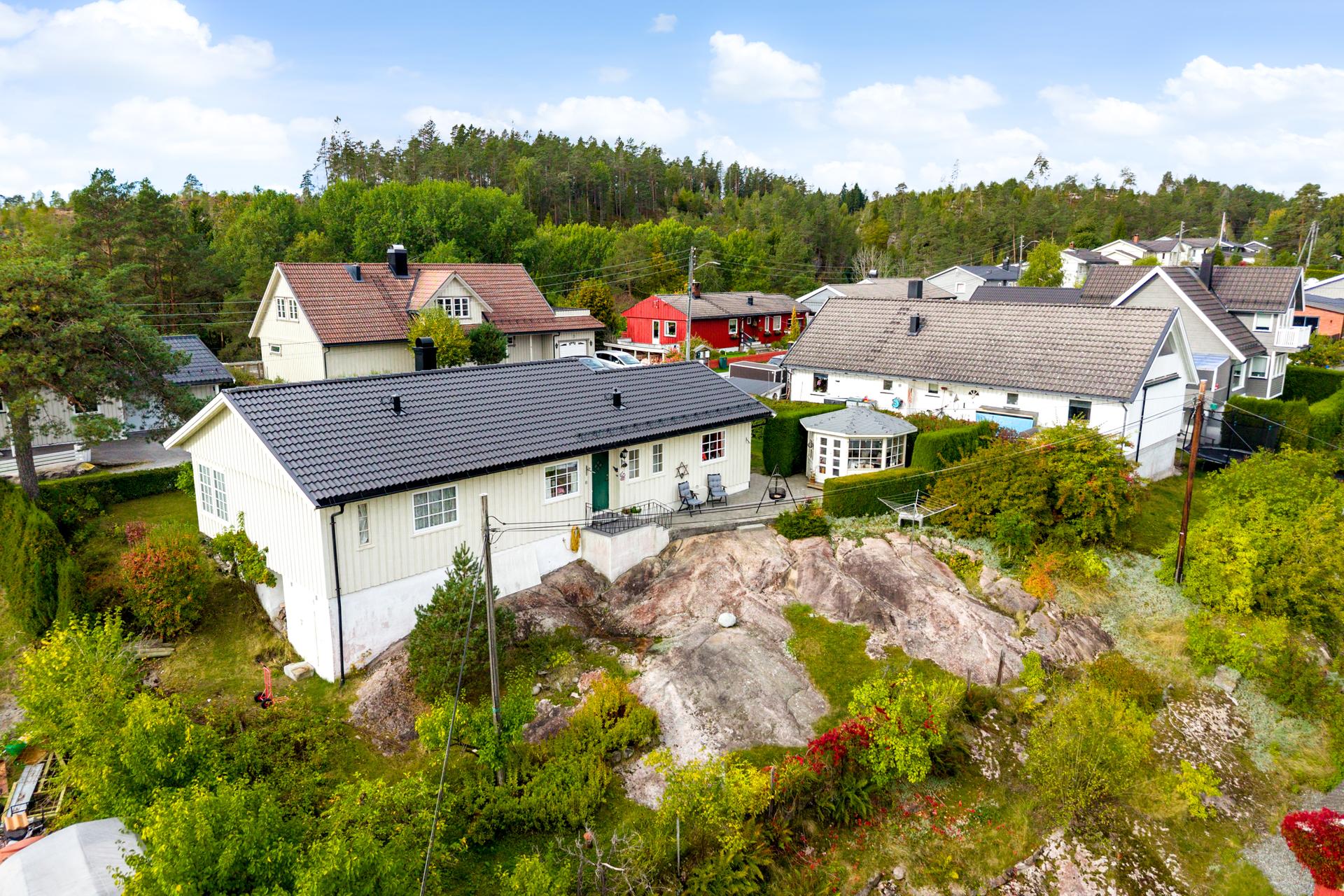 Baksiden av tomten består av naturlig fjellterreng og grenser til lysthuset.. Bilde nummer 3 av 3
