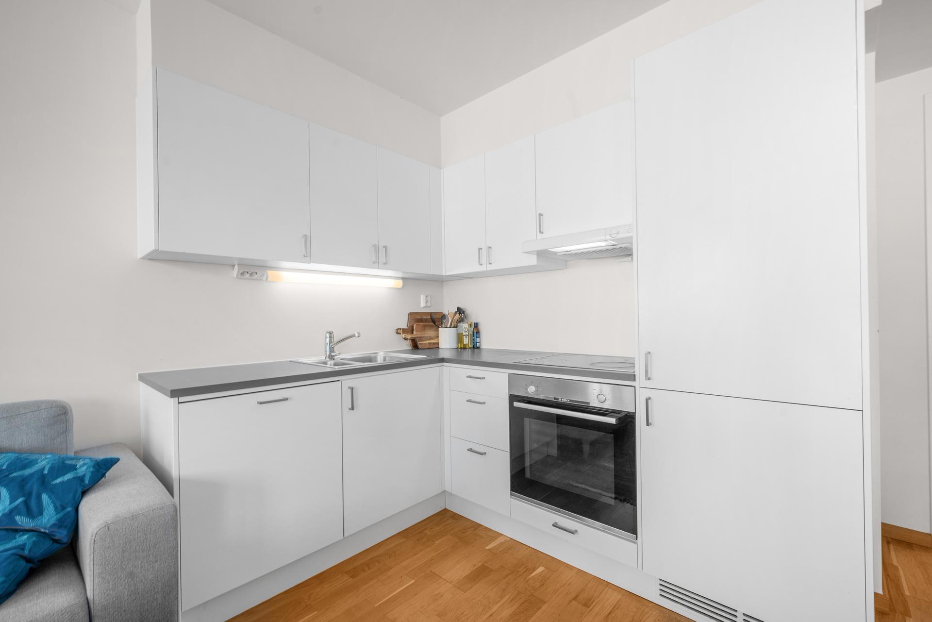 Kjøkkeninnredning fra 2018 med integrerte hvitevarer og laminat benkeplate.. Bilde nummer 3 av 3