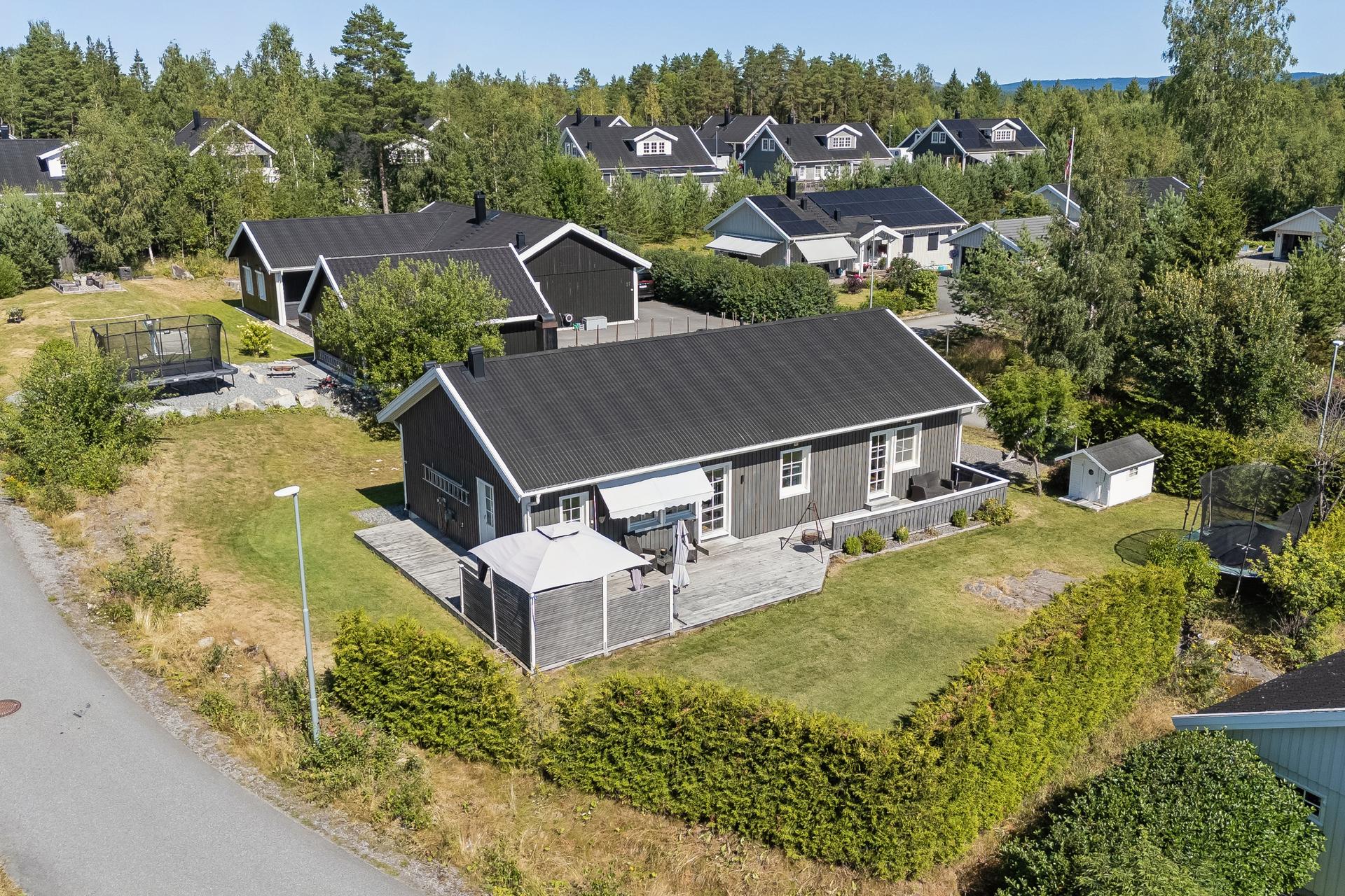 Stor, sydvestvendt terrasse på 55 m² som strekker seg langs boligens fasade.. Bilde nummer 3 av 3