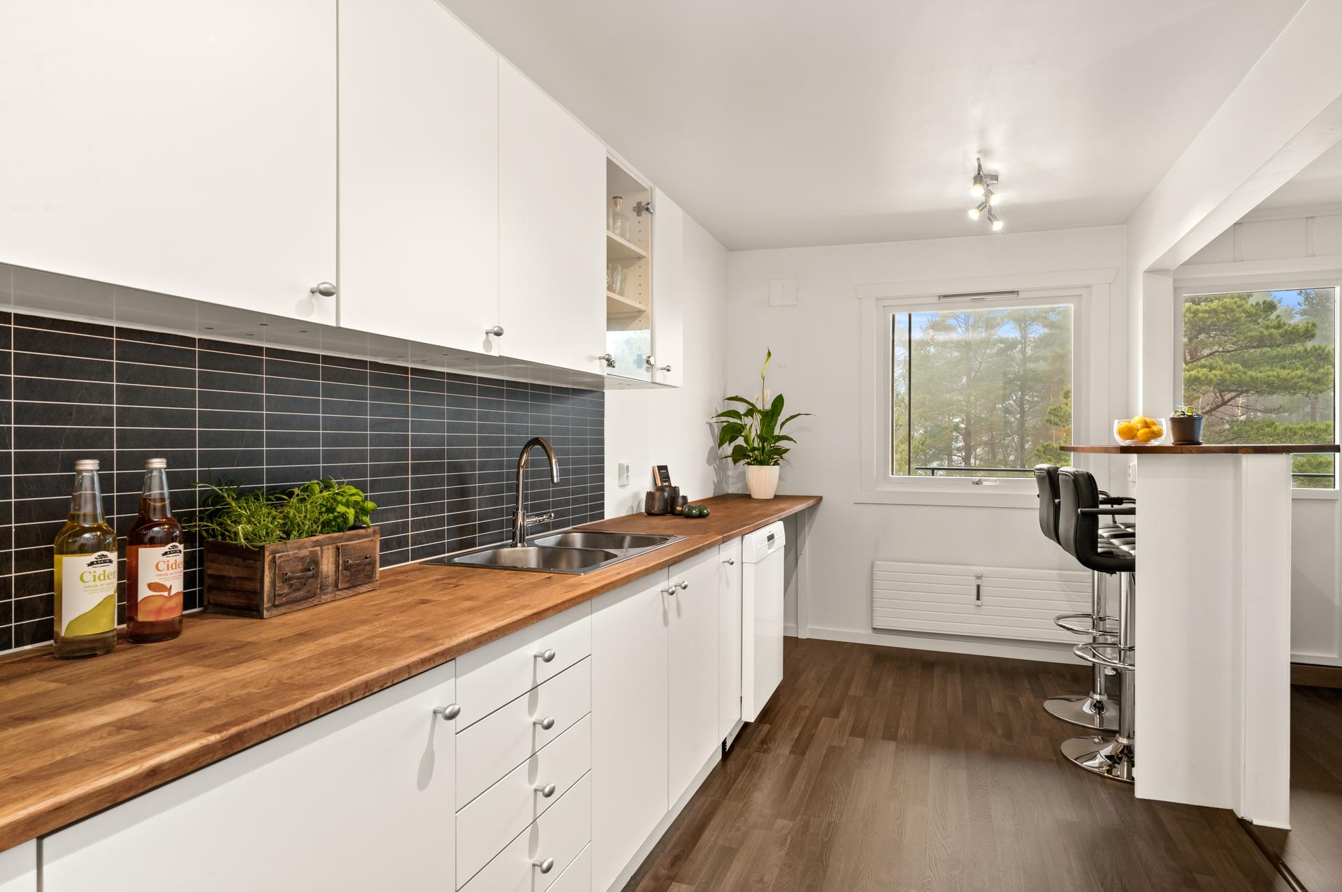 Leiligheten har et moderne kjøkken med glatte fronter og en solid benkeplate i heltre.. Bilde nummer 3 av 3