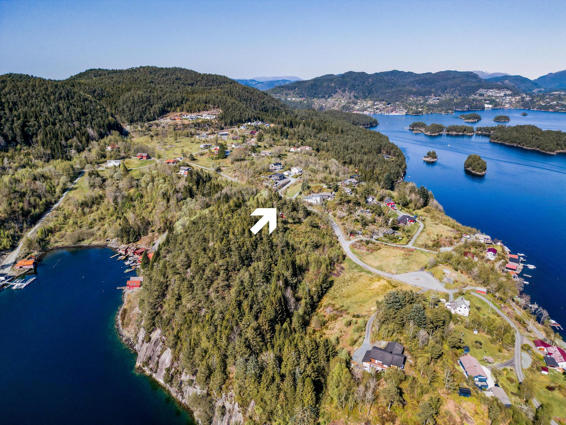 Tomten ligger fint plassert på en høyde. I bakgrunnen ser vi innover til Askvik og Hagavik.. Bilde nummer 2 av 3