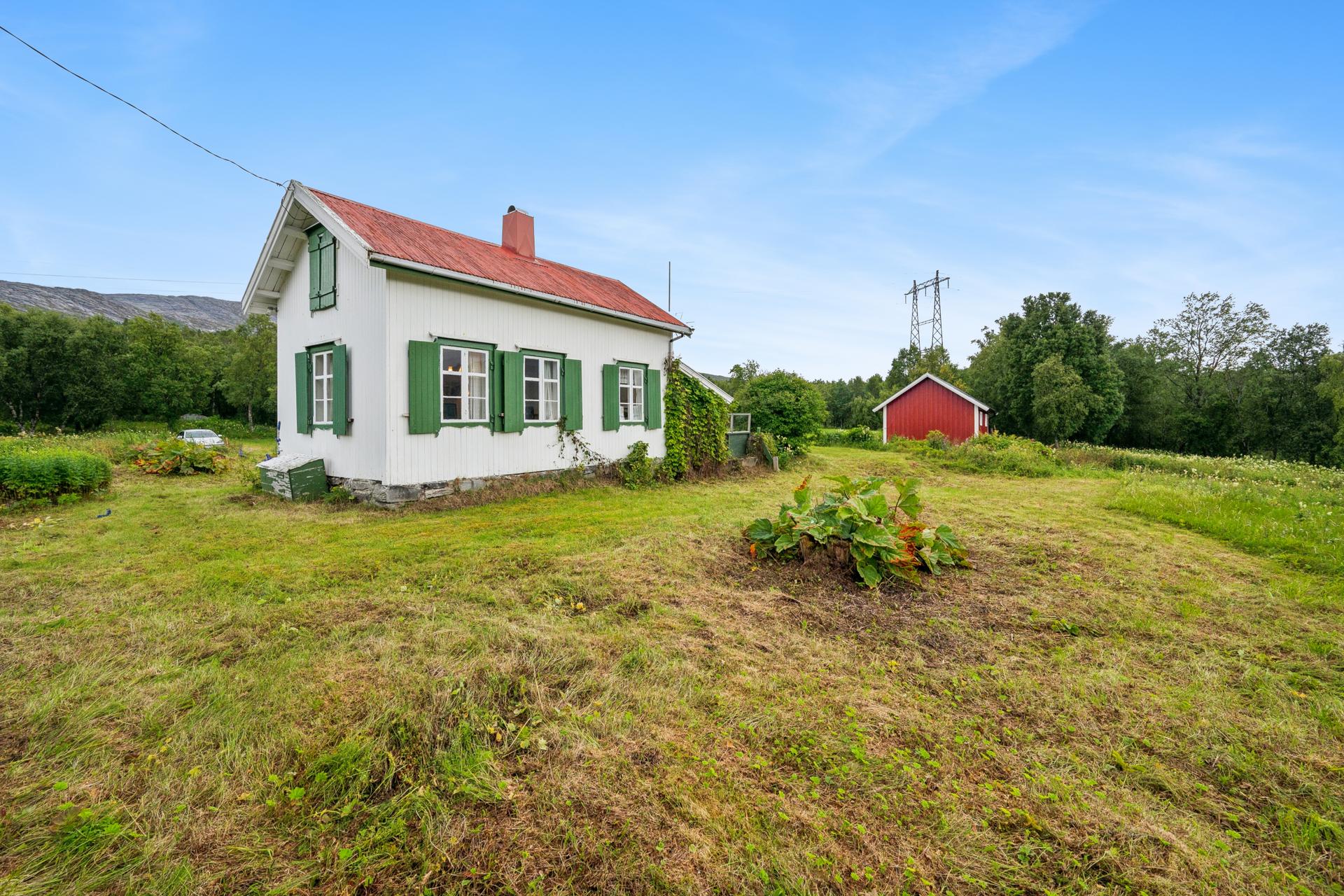 Eneboligen/fritidsboligen har en tradisjonell stil med hvitmalt panel og grønne skodder.. Bilde nummer 3 av 3