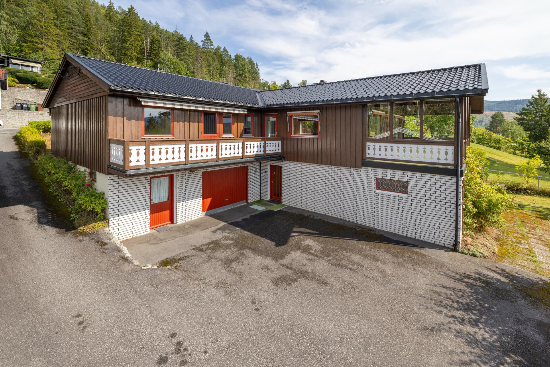 Asfaltert gårdsplass med parkering og adkomst til integrert garasje.. Bilde nummer 2 av 3