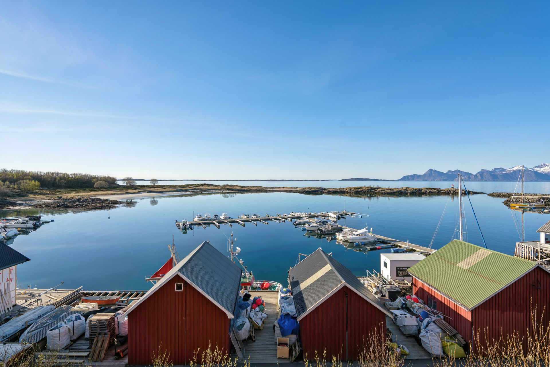 Fra eiendommen har du en vidstrakt utsikt over småbåthavnen, holmer og skjær, med fjellene i horisonten.. Bilde nummer 2 av 3