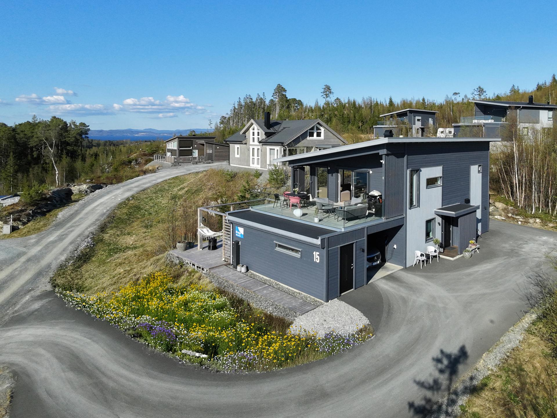 Moderne og innholdsrik hytte med bl. a. 2 bad, 5 soverom og carport. Blomstereng er digitalt redigert, det vil bli sådd denne sommeren. . Bilde nummer 2 av 3