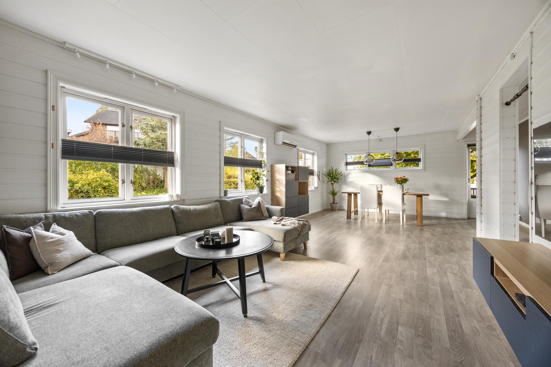 Stuen har en åpen planløsning med god plass til sittegrupper. . Bilde nummer 3 av 3