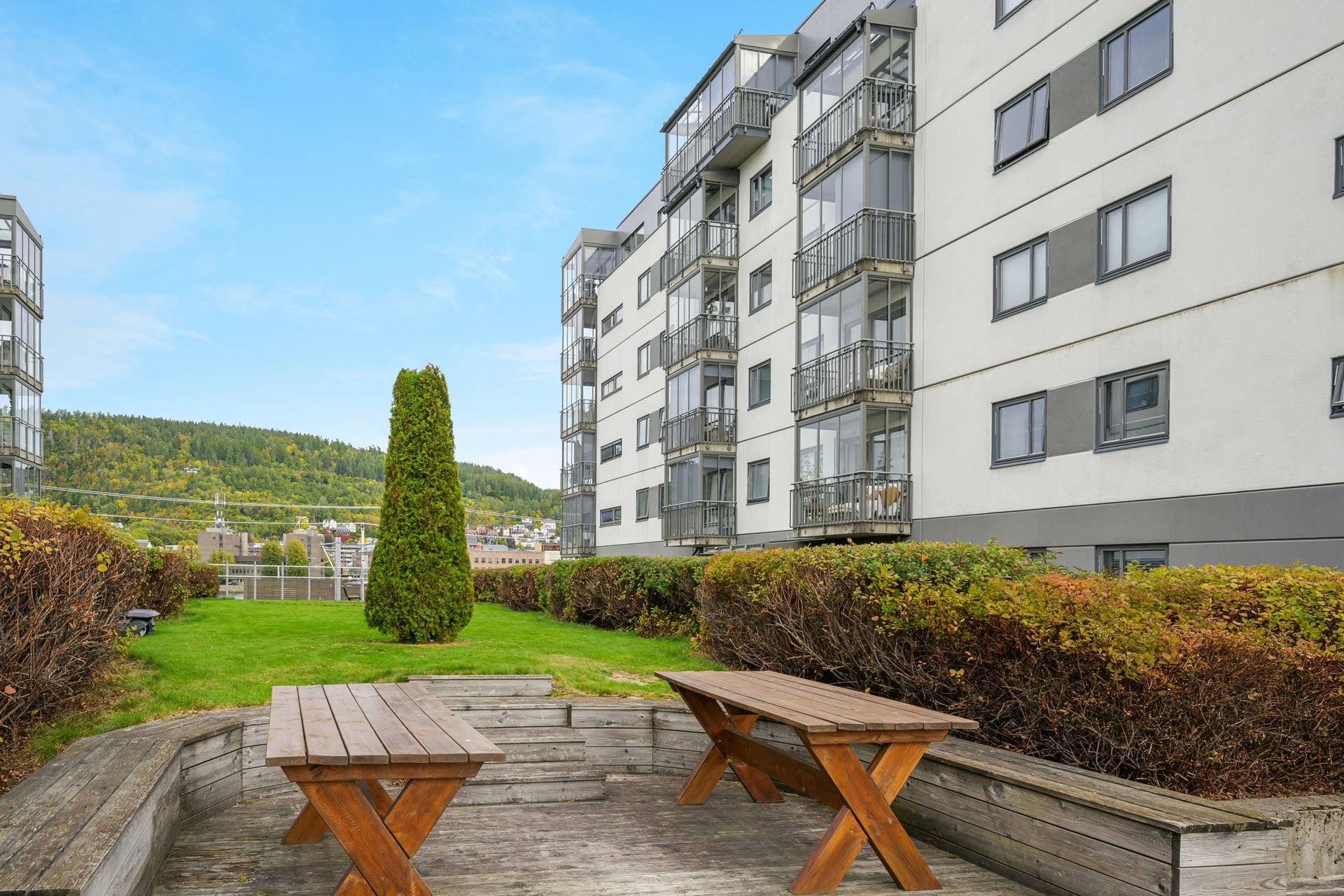 Fellesområdene er pent opparbeidet med plen, sittegrupper og felles takterrasse.. Bilde nummer 3 av 3