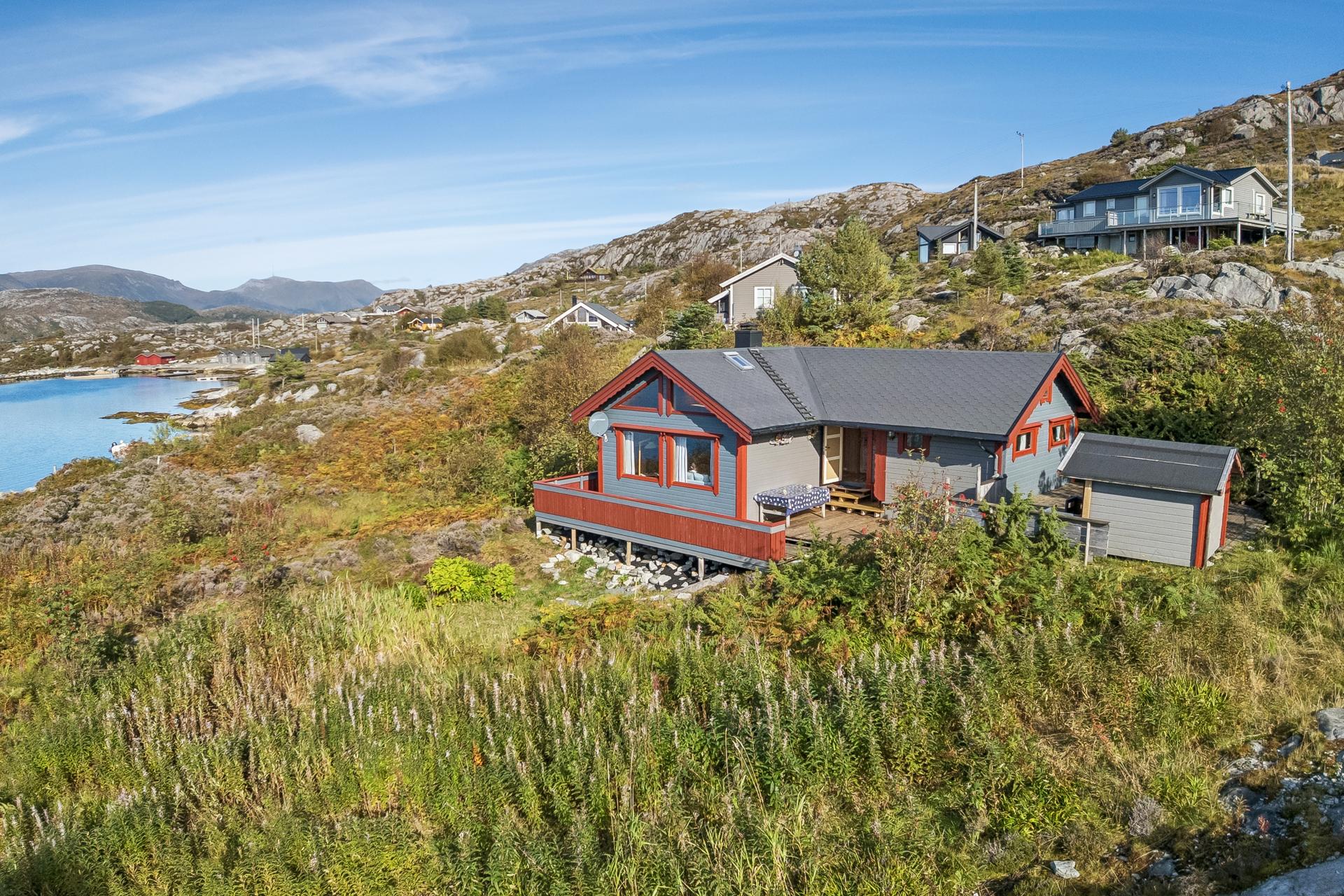 Smørhamnsøya ligg idyllisk til i kystlandskapet med kort avstand til handelsstaden i Smørhamn og fiskeværet Kalvåg.. Bilde nummer 2 av 3