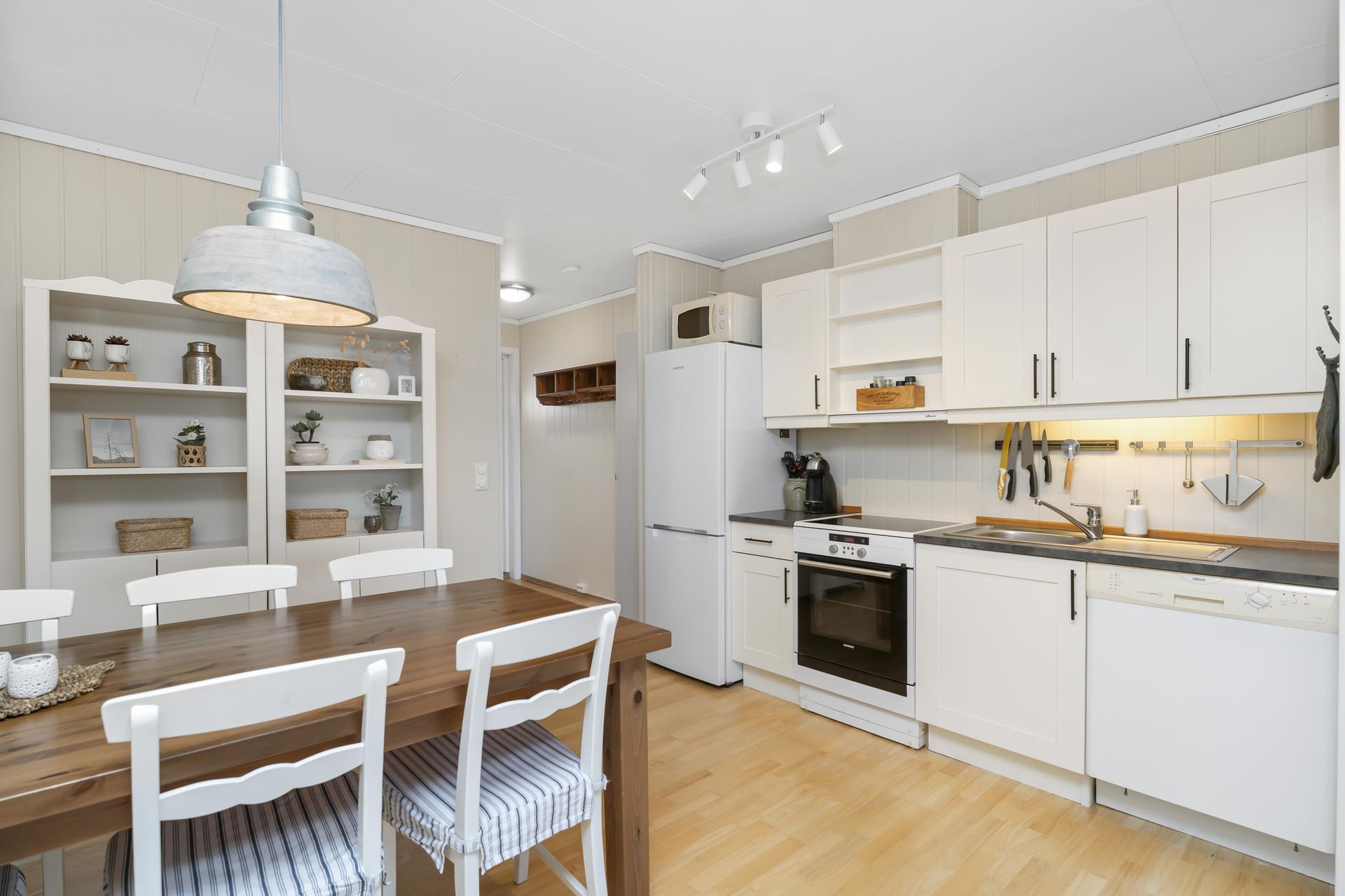 Kjøkkenet har et moderne design med profilerte fronter, laminat benkeplate og alle nødvendige hvitevarer. Bilde nummer 2 av 3