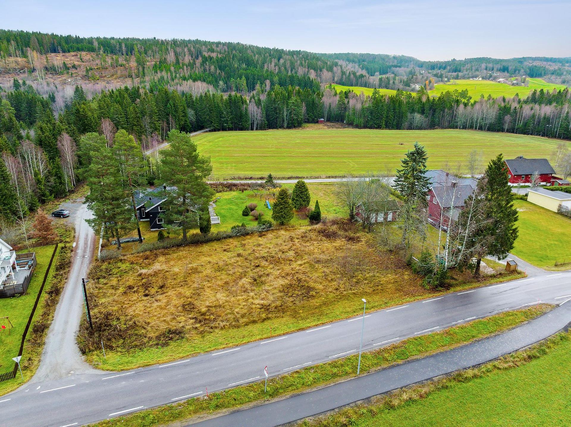 Tomten ligger i åpne og landlige omgivelser i Eidsvoll, med utsikt mot skog og kulturlandskap.. Bilde nummer 2 av 3