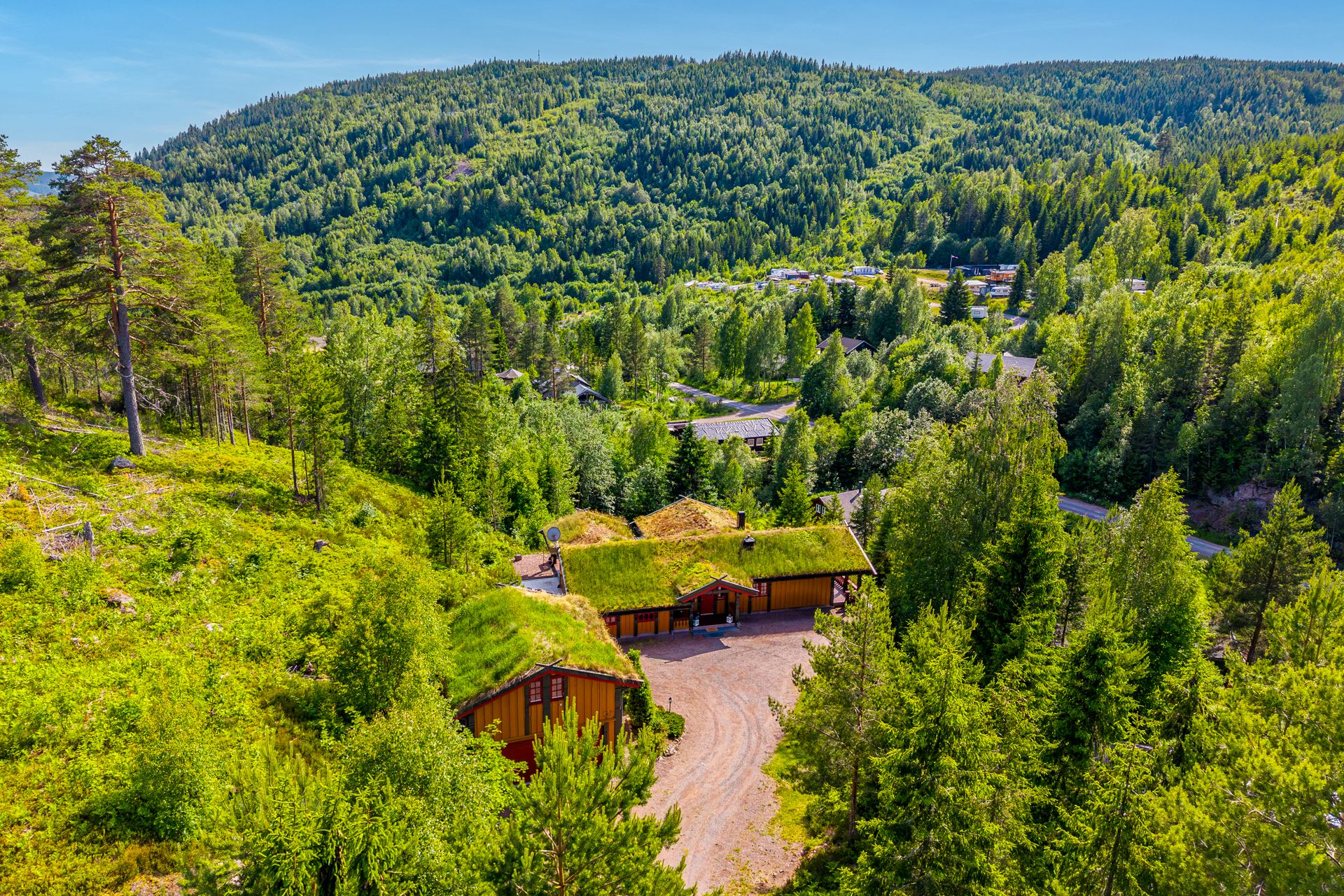 Eiendommen ligger flott i terrenget og med naturlig vegetasjon . Bilde nummer 2 av 3