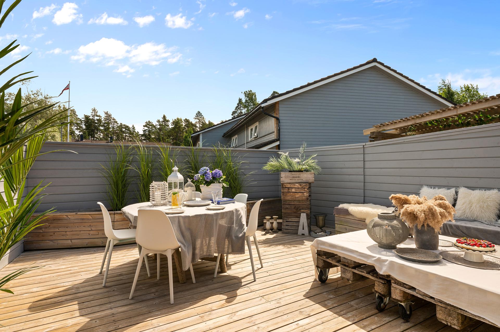 Fra kjøkkenet er det utgang til en romslig terrasse på ca. 32 m² med høye skjermvegger i tre.. Bilde nummer 3 av 3