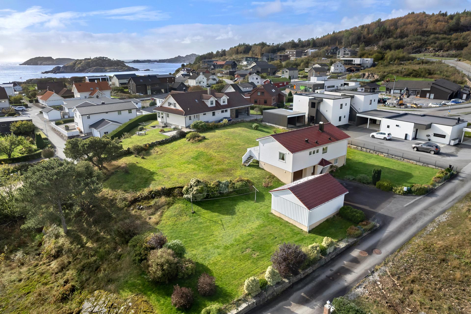 Den frittliggende enebolig går over to plan med romslig tomt og utsyn mot sjøen.. Bilde nummer 2 av 3