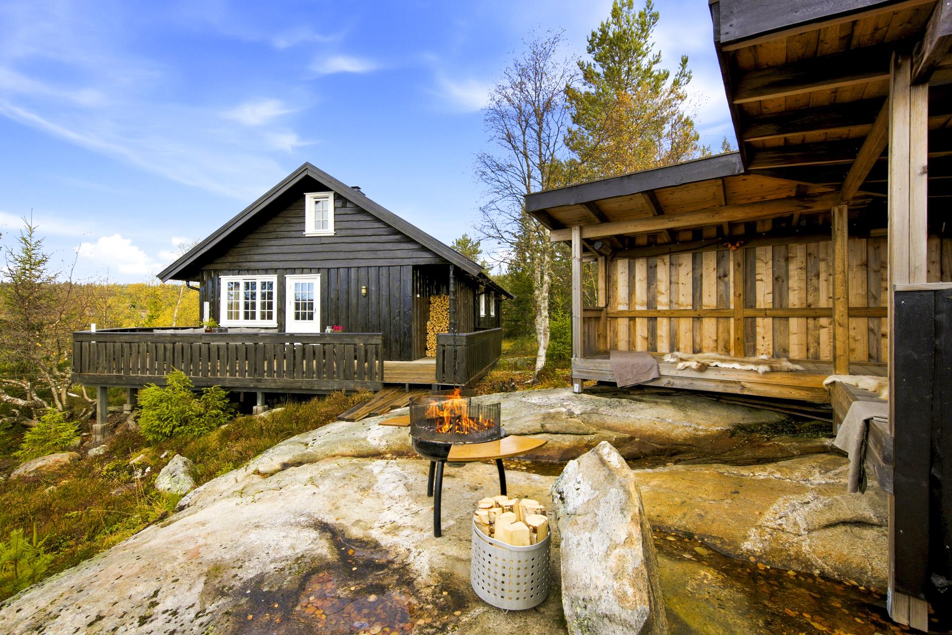 Hytta og gapahuken er tilpasset det kuperte fjellterrenget.. Bilde nummer 3 av 3