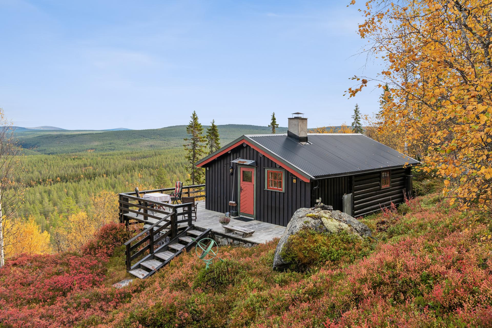 Hytta ligger høyt og fritt i terrenget med trappeadkomst ned til naturtomten.. Bilde nummer 3 av 3