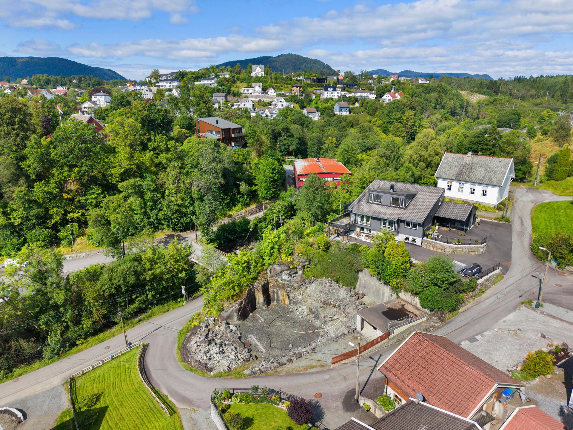 Eiendommen er omkranset av skogkledde åser og etablerte villaområder.. Bilde nummer 2 av 3
