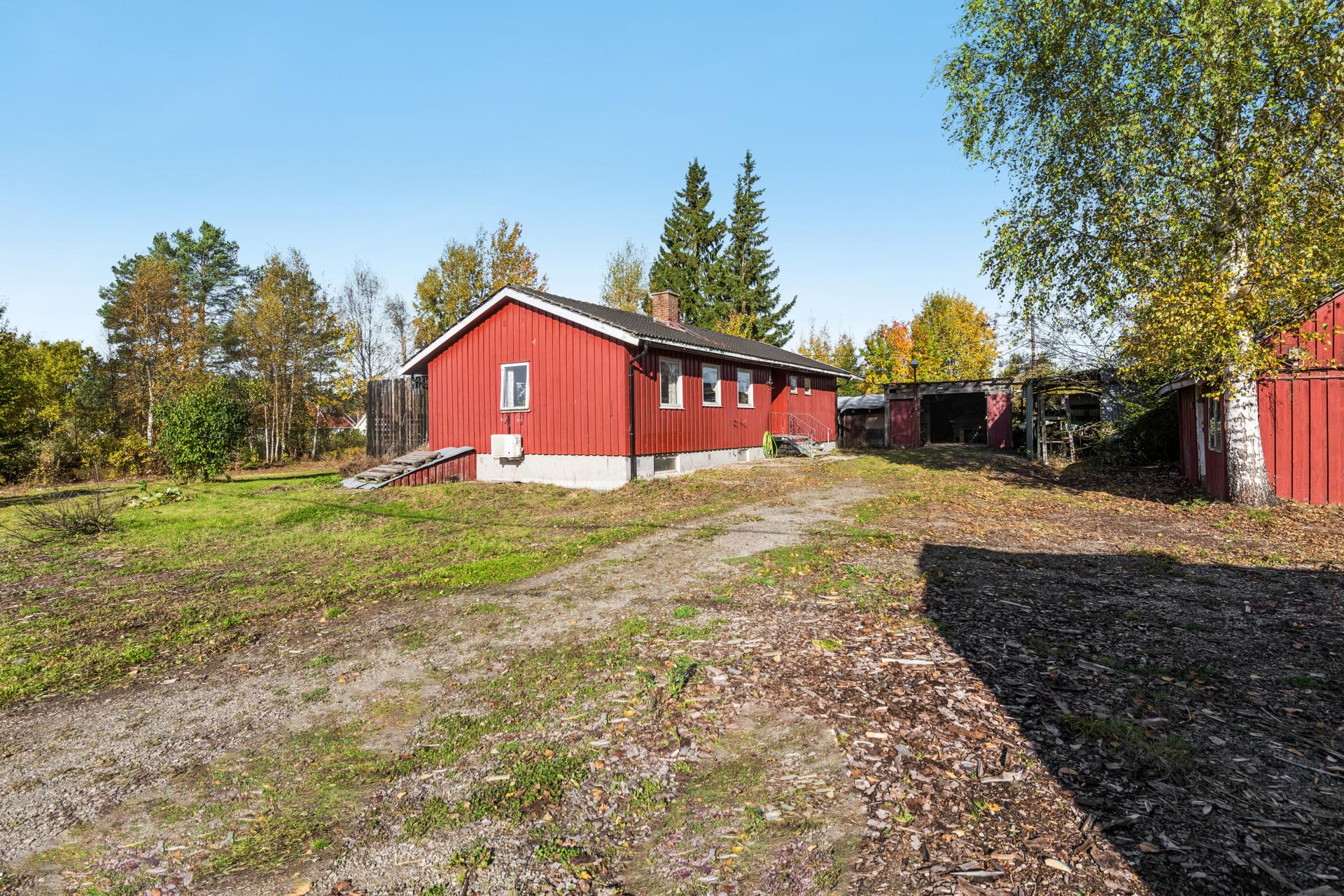 Eiendommen byr på en romslig tomt med gruset innkjøring og flere frittstående bygg.. Bilde nummer 3 av 3
