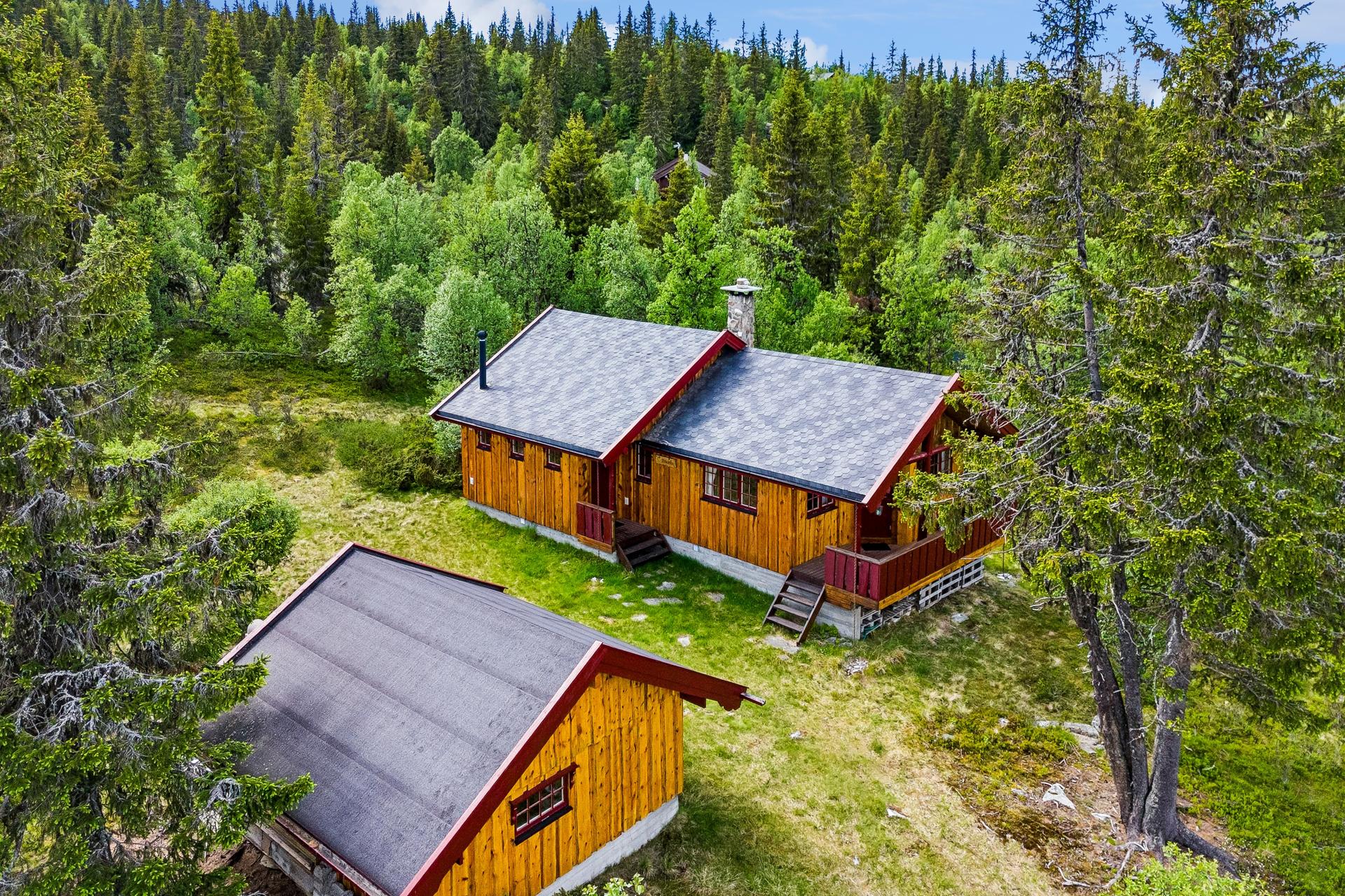 Eiendommen består av en fritidsbolig fra 1996 og et frittstående uthus på 12 m².. Bilde nummer 3 av 3