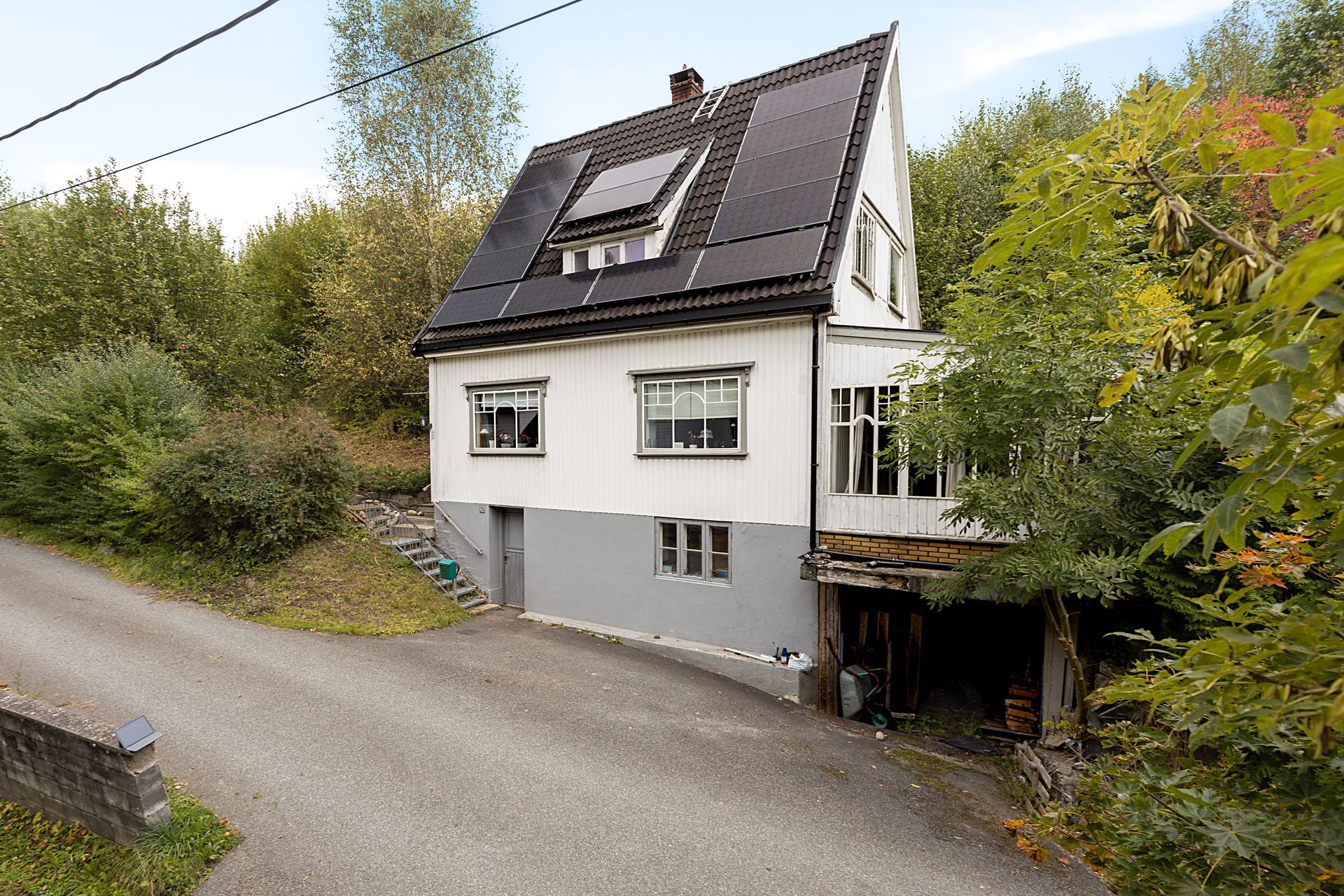 Enebolig over tre plan med solcelleanlegg på taket og integrert garasje i kjelleren.. Bilde nummer 2 av 3