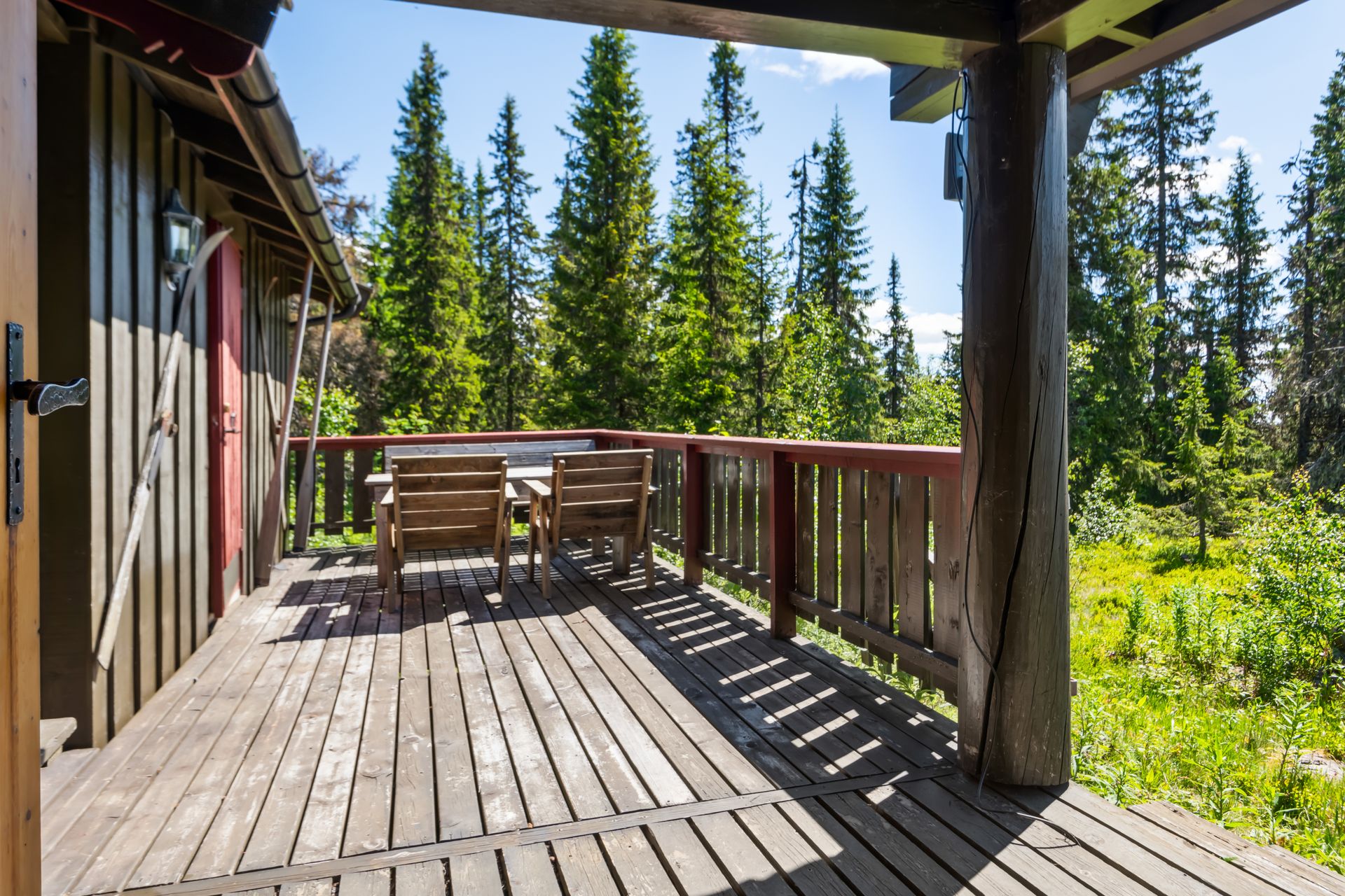 Solrik terrasse som binder hytta og uthuset sammen.. Bilde nummer 2 av 3