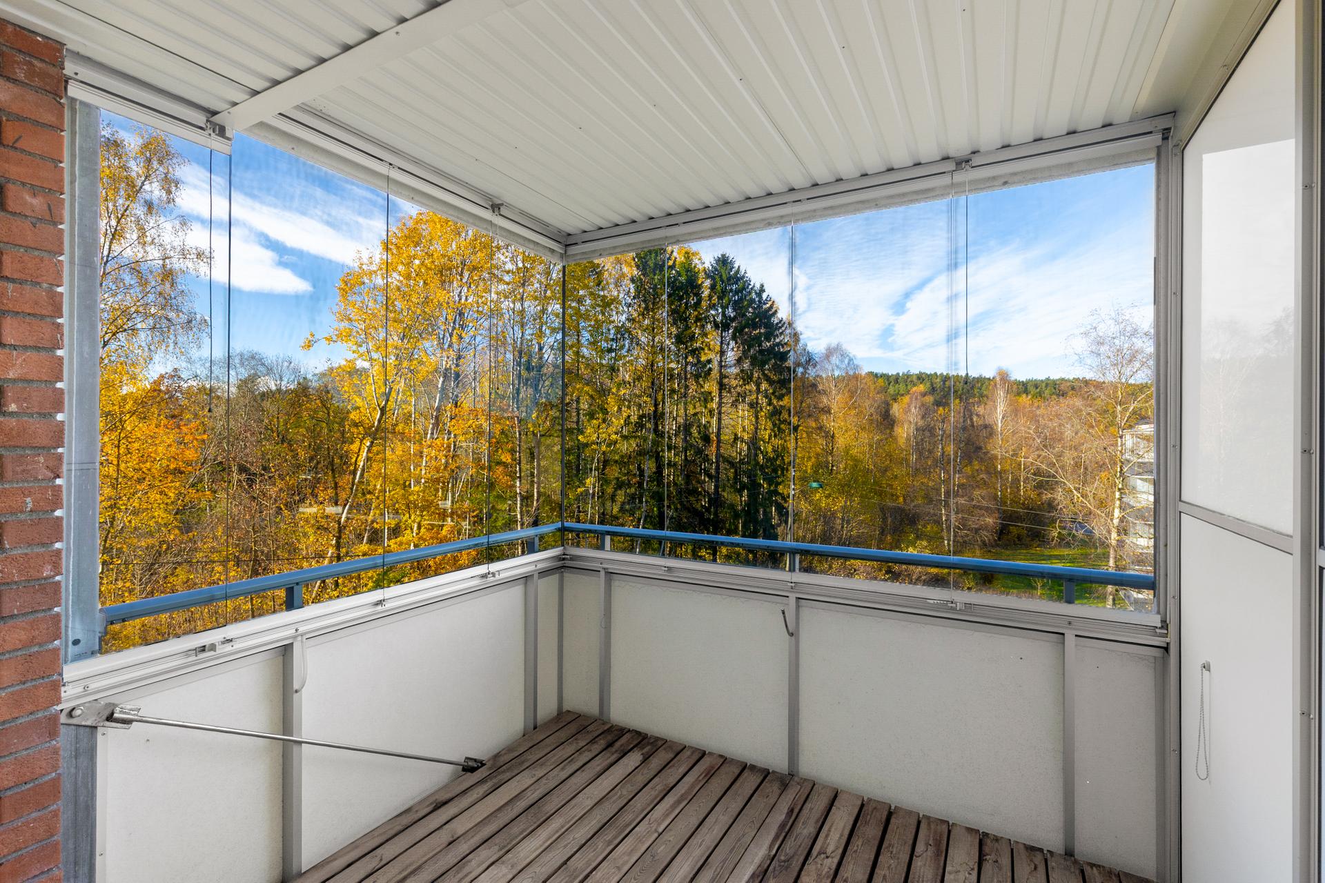 Vestvendt innglasset balkong med foldeglass og tregulv over betongdekke.. Bilde nummer 2 av 3