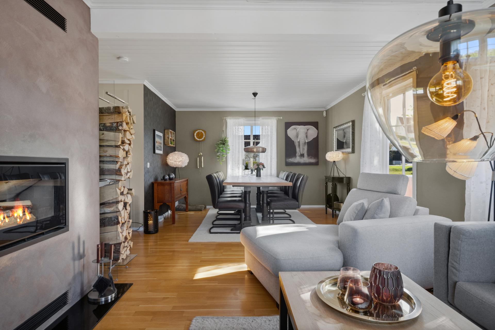 Husets naturlige samlingspunkt er den romslige stue- og spisestuen. Her skaper den elegante designpeisen både varme og stemning, samtidig som de store vindusflatene slipper inn rikelig med dagslys. . Bilde nummer 3 av 3