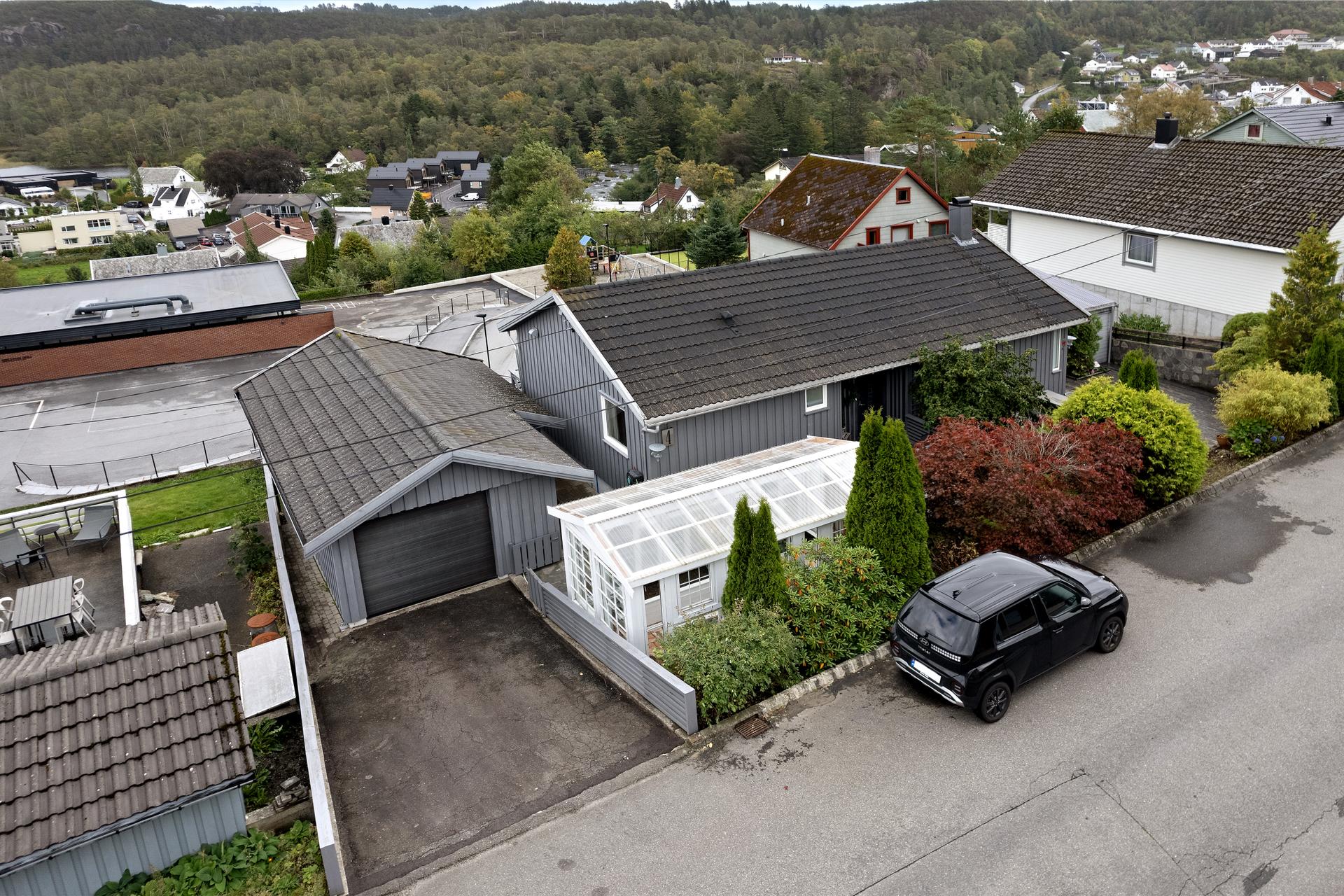 Enebolig over to plan med pent opparbeidet tomt, garasje, overbygd terrasse, lekehytte og drivhus.. Bilde nummer 2 av 3