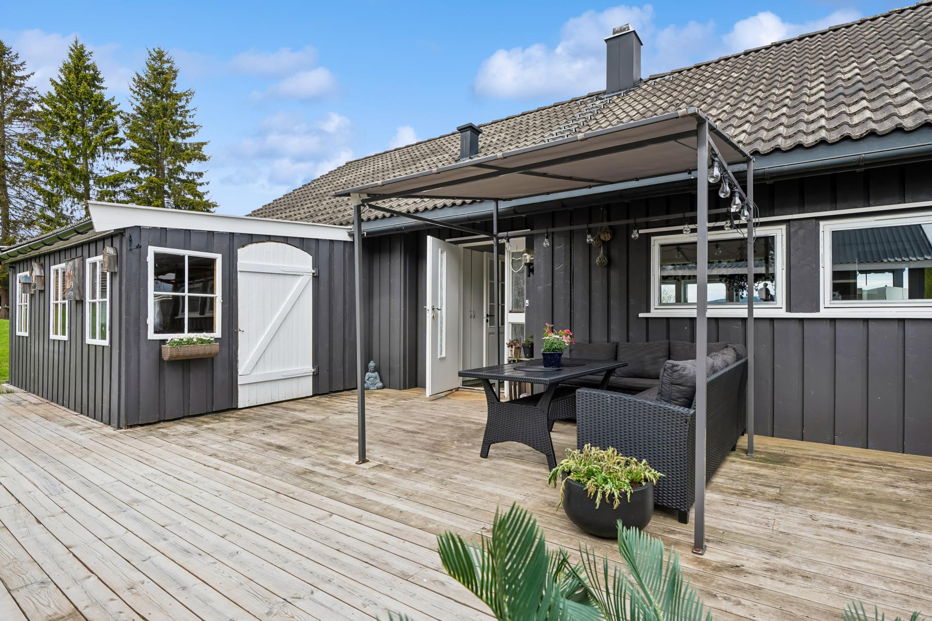 Eiendommen har en romslig og usjenert terrasse med tilgang til utestue.. Bilde nummer 2 av 3
