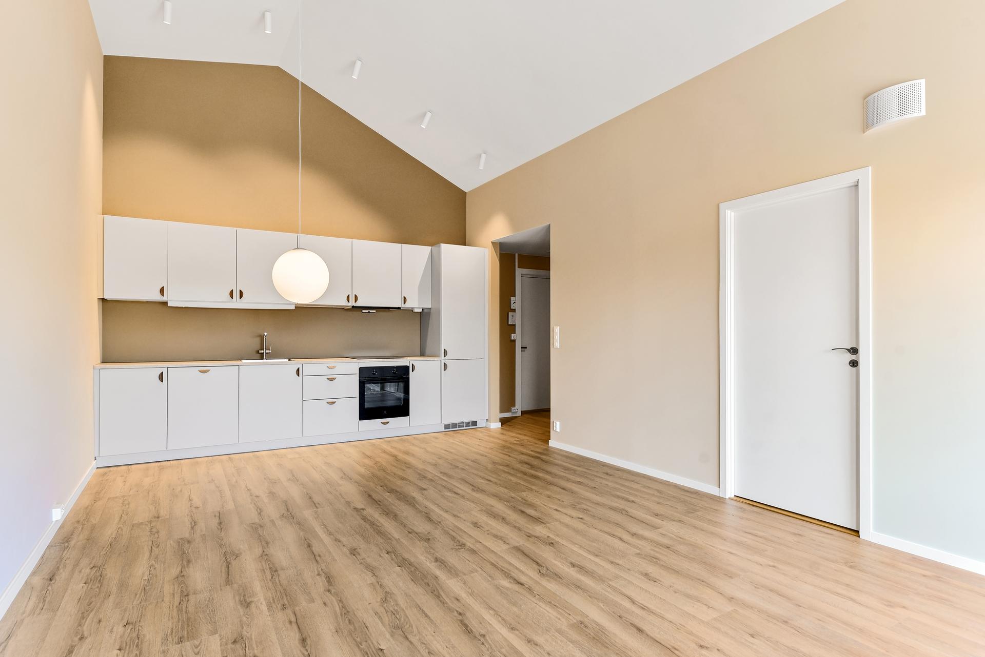 Leiligheten har røstet himling med flott takhøyde, noe som gjør at leiligheten virker større, mer luftig og får et særegent preg utenom det vanlige. Spotter i tak over kjøkken. Foto: Jenserud Foto (Kjell Vidar Martinsen). Bilde nummer 1 av 3