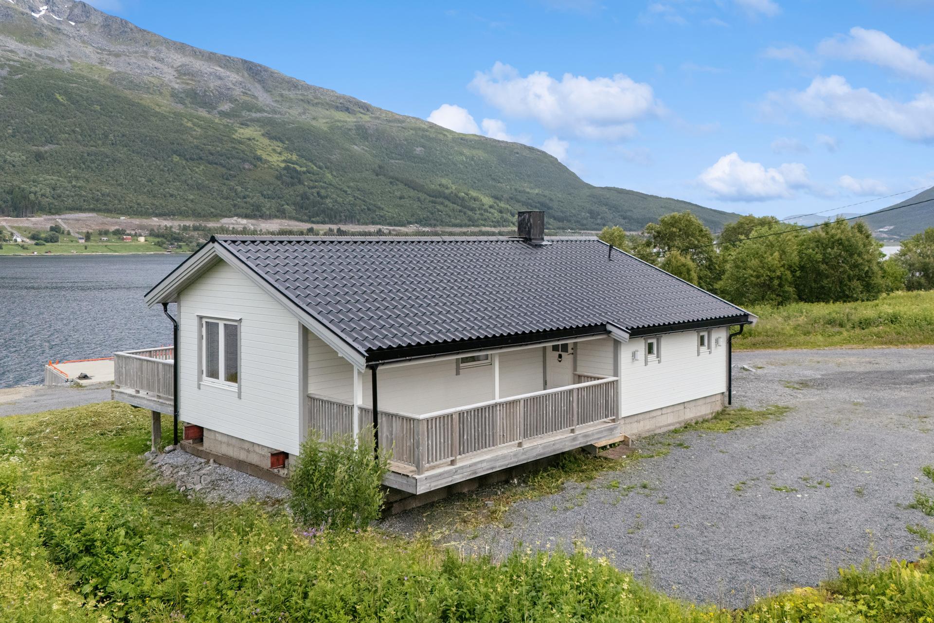 Hytta har liggende kledning, stålplater i steinprofil på taket og overbygd terrasse ved inngangspartiet. Bilde nummer 2 av 3