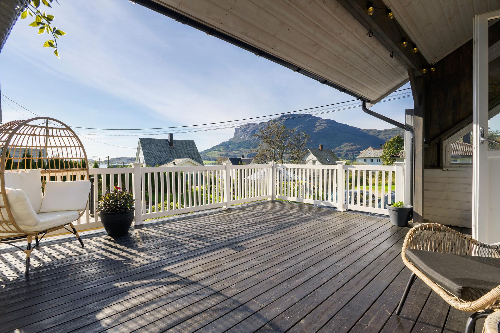 Einebustad over tre plan med stor terrasse og vid utsikt mot fjord og fjell.. Bilde nummer 2 av 3
