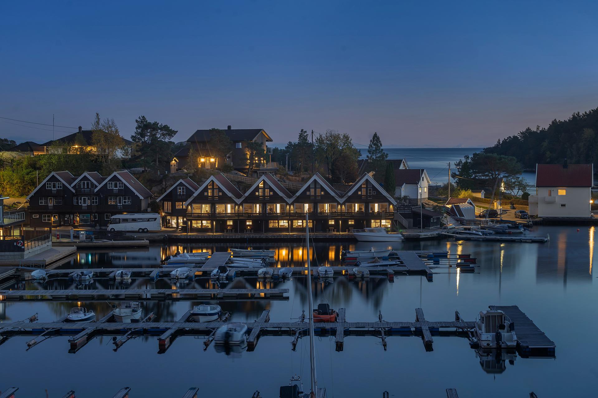 Kveldsstemning over Trysnes, med lys fra leilighetene og båtene.. Bilde nummer 2 av 3