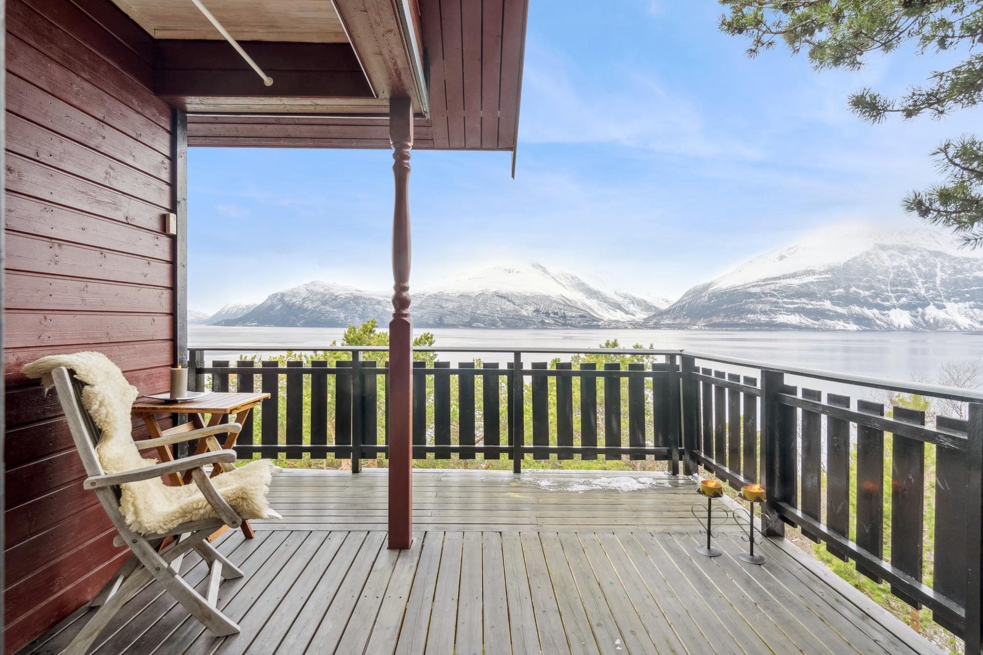 Den delvis overbygde verandaen vender mot Storfjorden med utsikt over fjord og fjell.. Bilde nummer 3 av 3