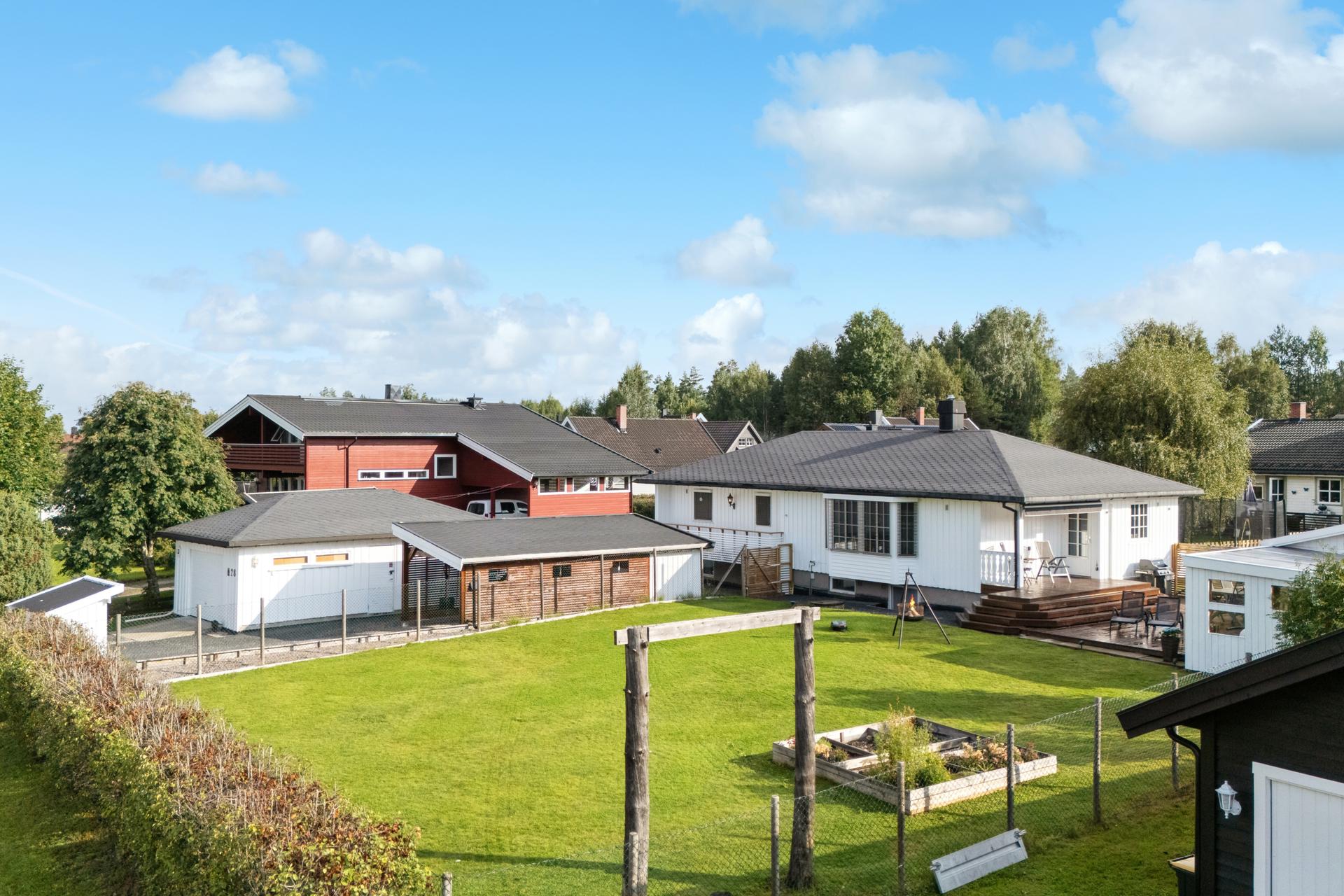 Eiendommen har en stor og flat tomt, opparbeidet med plen og gruset innkjøring. . Bilde nummer 2 av 3