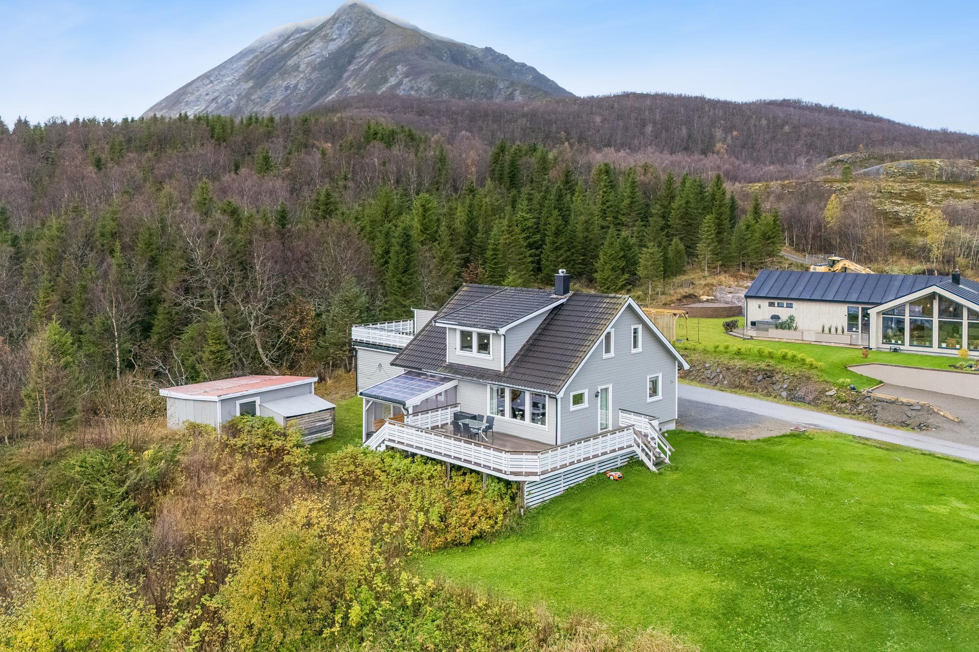 Boligen ligger fint plassert i terrenget med mektige fjell like bak eiendommen.. Bilde nummer 3 av 3