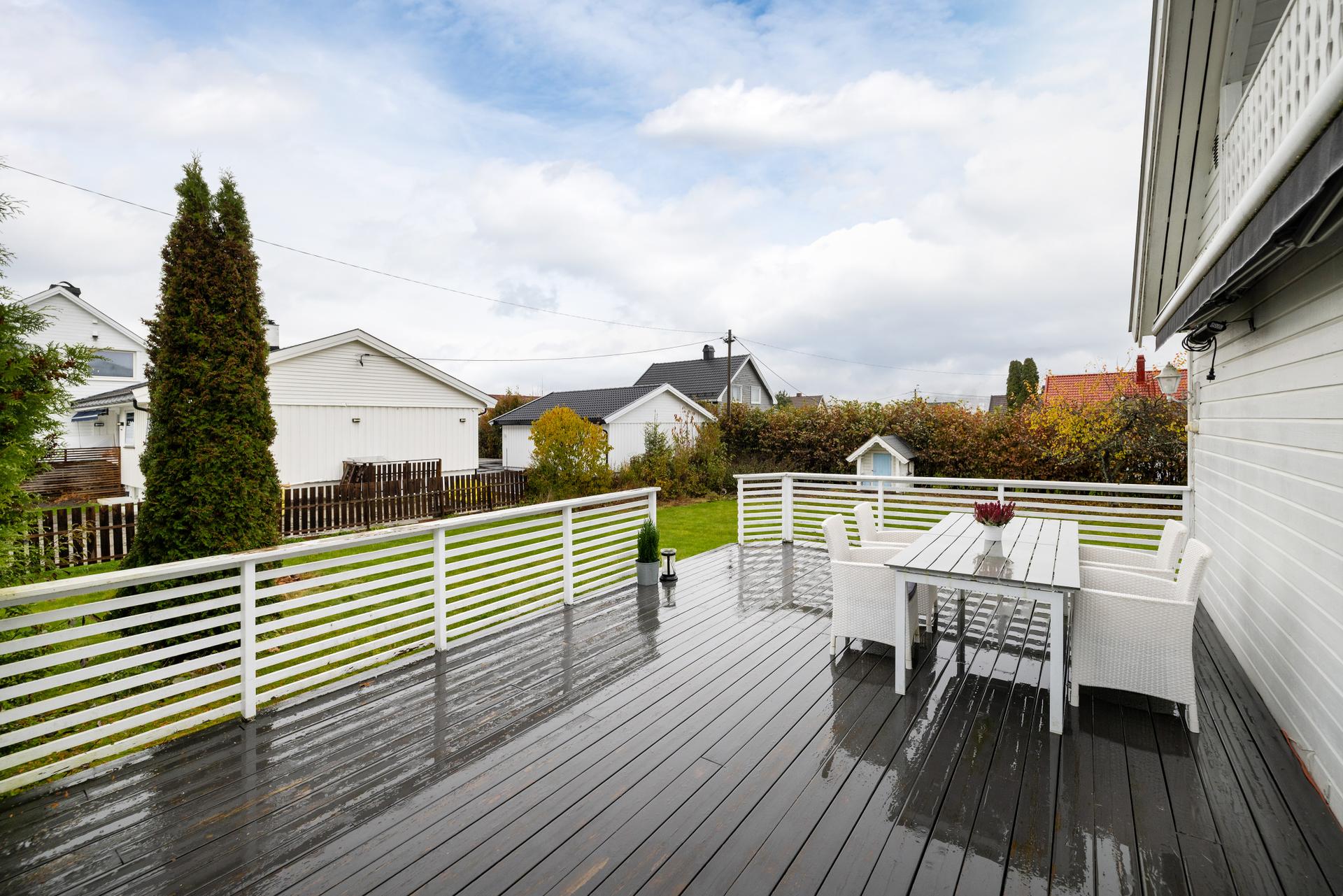 Terrassen er oppført i treverk med stående rekkverk og har god plass til spisebord og sittegruppe.. Bilde nummer 2 av 3