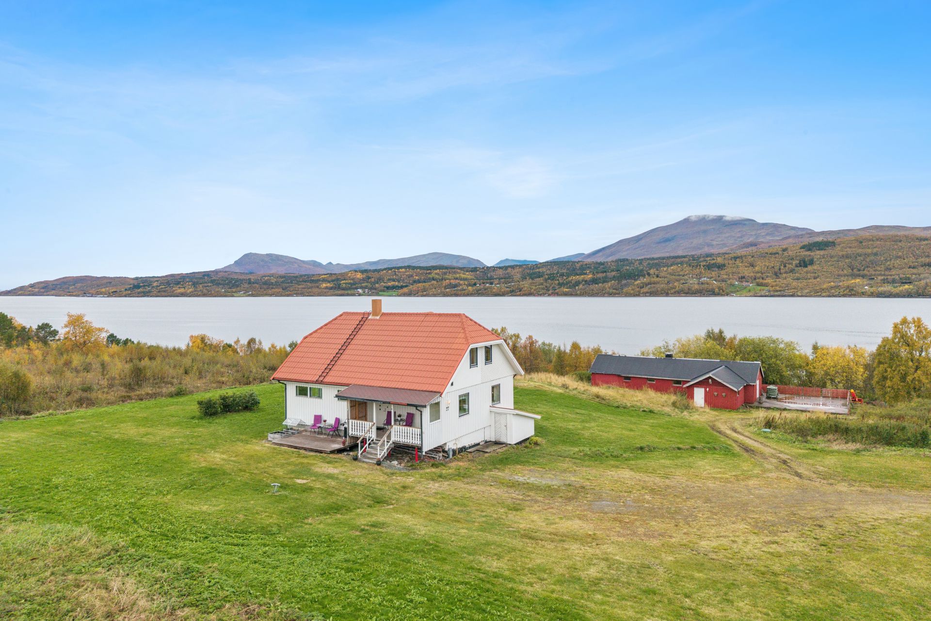 Eneboligen ligger fritt til i terrenget med utsikt over fjorden og fjellene.. Bilde nummer 2 av 3